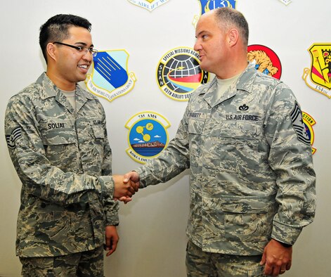Chief Master Sgt. Dwight Badgett, command chief master sergeant, Air Force Reserve Command, presents Staff Sgt. Tony Solilai, a Reservist assigned to the 624th Aeromedical Staging Squadron, 624th Regional Support Group, with his command chief coin June 12. Chief Badgett met with Reservists of the 624th RSG in small groups during the June unit training assembly as part of his visit to Hawaii and Guam. (U.S. Air Force photo/Senior Airman Kimberly Erickson)