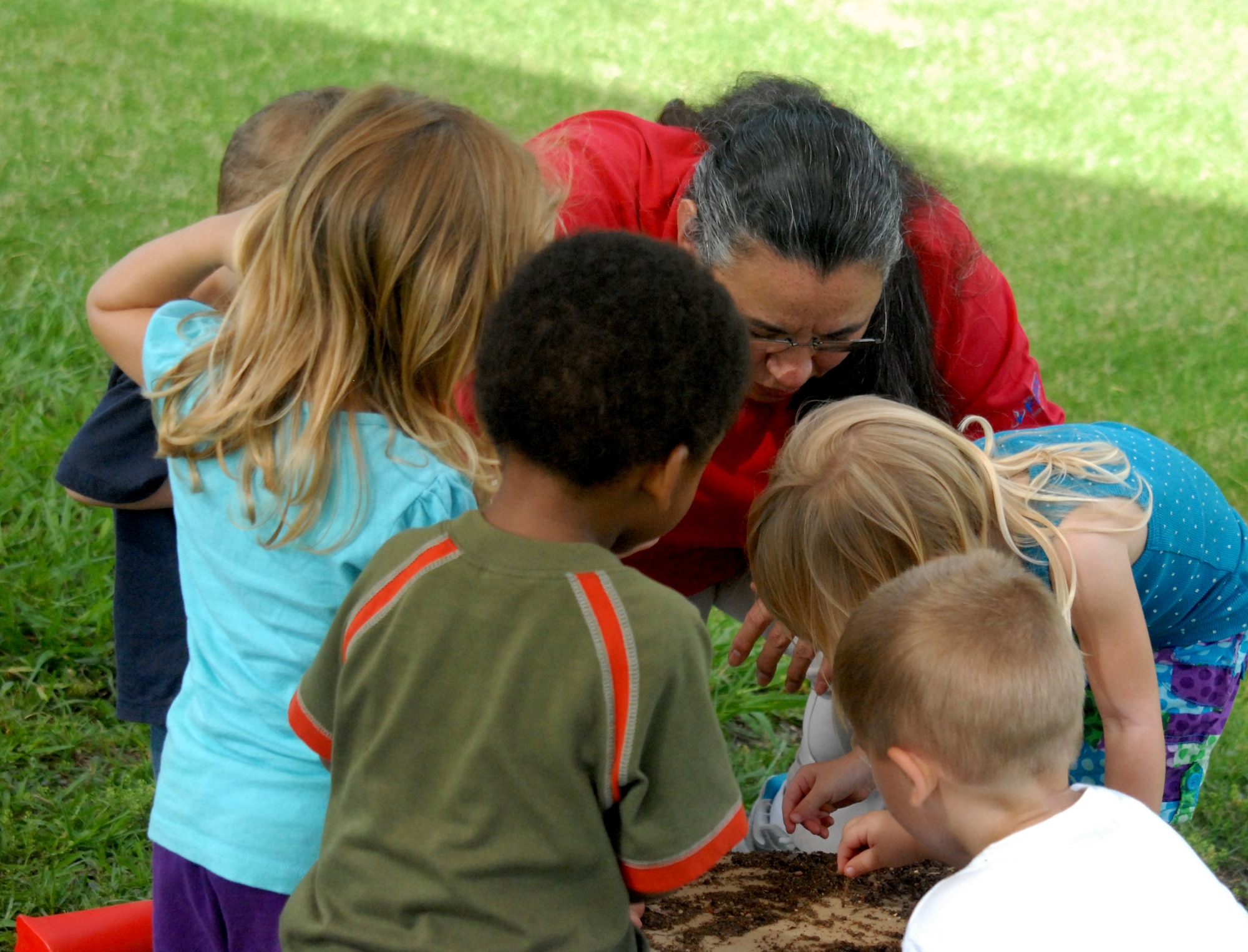 Alicia Fuentez, Child Development Center, talks to some of her pre-schoolers about earthworms July 5 while outside at the CDC. The Parent Advisory Board quarterly meetings offer parents and providers at the CDC, School Age, Youth Center and Youth Sports a way share new program ideas for the 300 youths that attend activities on base. (U.S. Air Force photo/Connie Hempel)