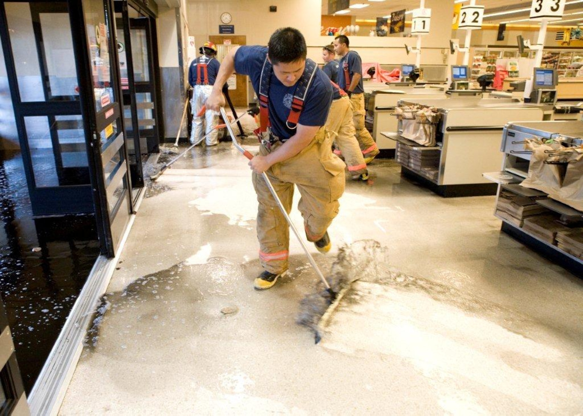 William Kim, Edwards Fire Department, removes standing water
from the base commissary after a broken sprinkler head flooded the store and
caused patrons to evacuate July 1. (Air Force photo by
Edward Cannon)
