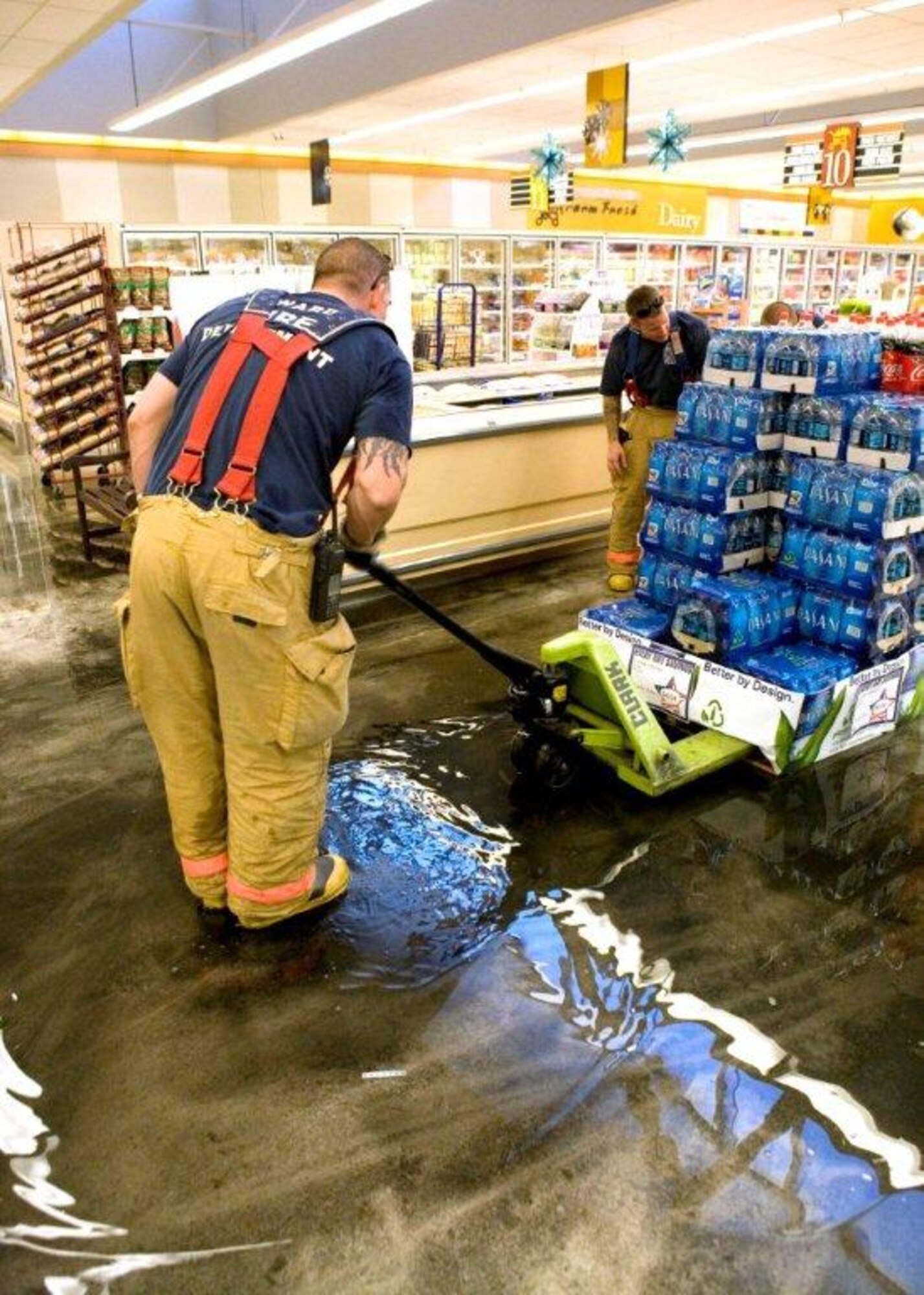 Fire crews work to save merchandise from damage after a water leak flooded the
commissary July 1. (Air Force Photo by Edward Cannon) 
