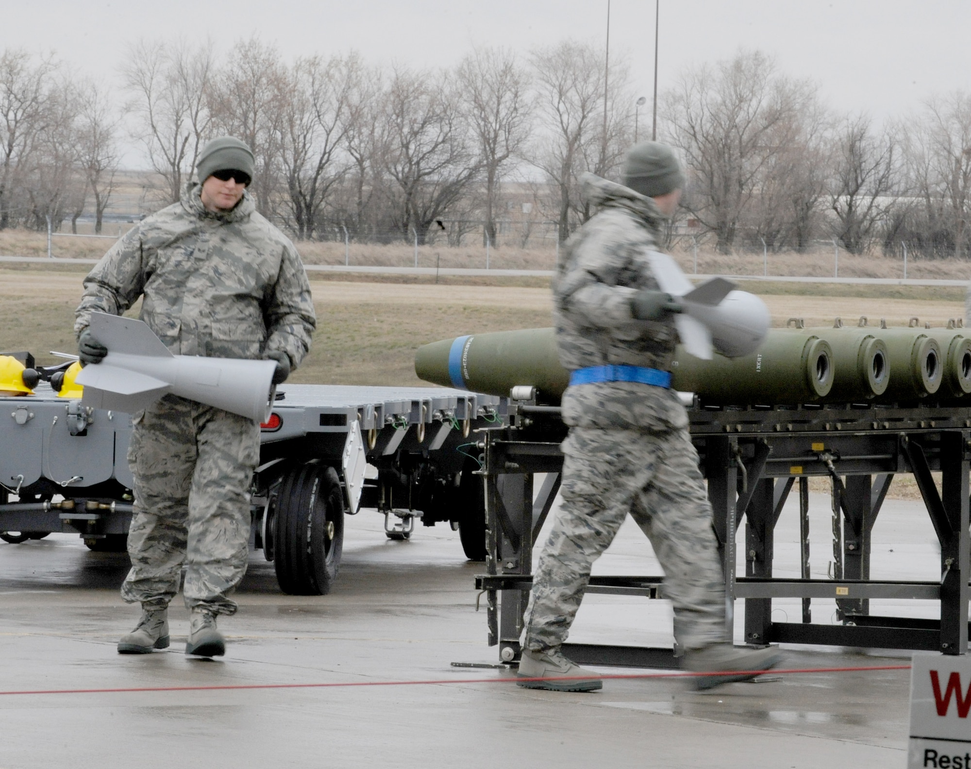 Load crew members attach fins to conventional bombs April 13, 2010, in a load crew competition at Minot Air Force Base, N.D. The 5th Bomb Wing joined six other bomb wings in Air Force Global Strike Command's first load competition here April 13 through 14. The evaluation was based not only on the Airmen's hands-on skills, but also on their knowledge in their respective career fields. (U.S. Air Force photo/Staff Sgt. Stacy Moless)