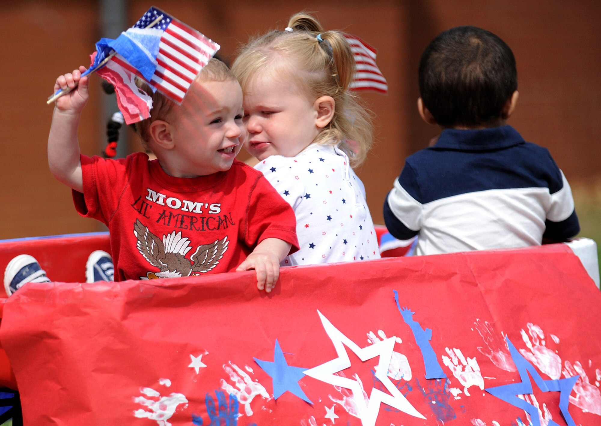 RAF MILDENHALL, England -- Gavin Petersen, 16-month-old son of Staff Sgt. Ryan Petersen, 321st Special Tactics Squadron, waves an American flag with two of his friends in the RAF Mildenhall Child Development Center's Independence Day Parade and Celebration July 2 at the CDC. Kids of all ages paraded from their bouncy castles to an appearance by the RAF Mildenhall Fire Department and Sparky the fire dog. The CDC's Parent Advisory Committee organized the event with free food, drinks and face painting. (U.S. Air Force photo/Staff Sgt. Jerry Fleshman)