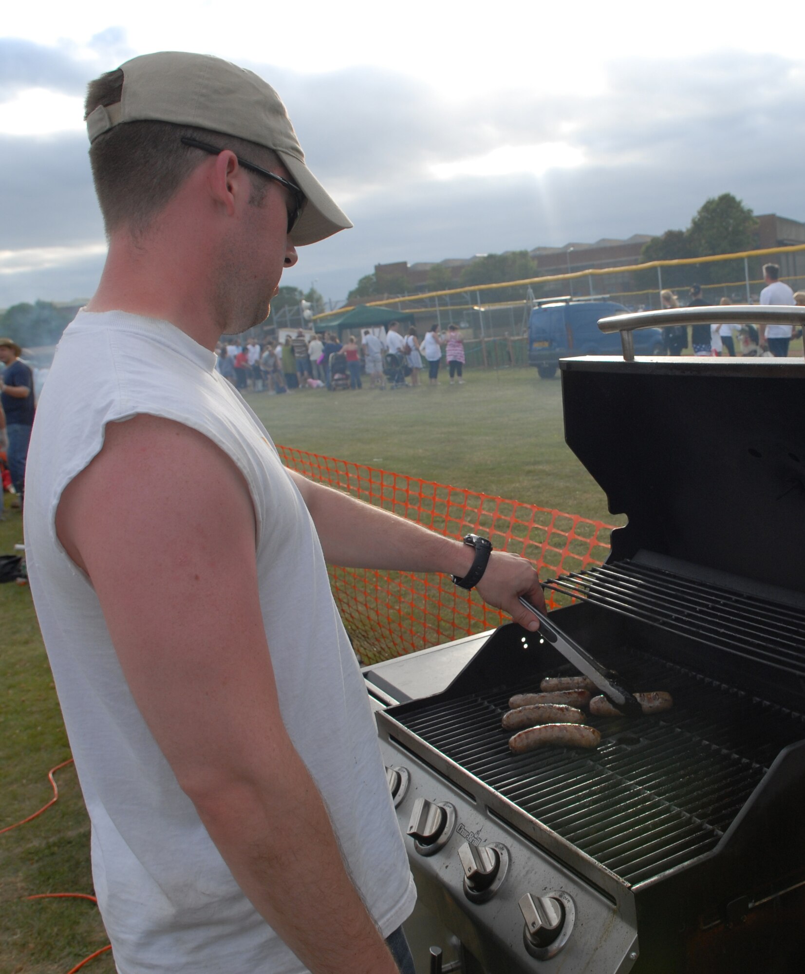 RAF MILDENHALL, England – Staff Sgt. Joshua Campbell, 488th Intelligence Squadron, cooks sausages for his unit food booth at the 4th of July celebration, RAF Feltwell.   (U.S. Air Force photo/Staff Sgt. Christopher L. Ingersoll)