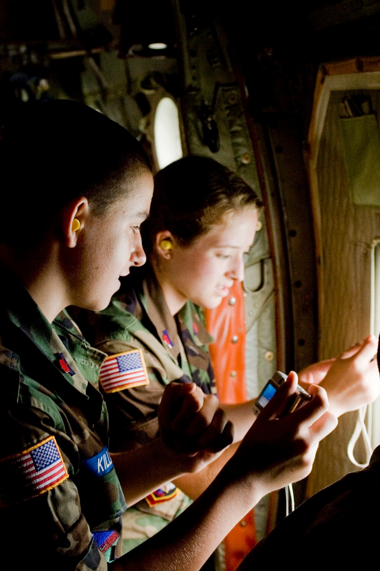 YOUNGSTOWN AIR RESERVE STATION, Ohio--A pair of Civil Air Patrol (CAP) cadets take pictures through the window of a C130H aircraft during a flight to Wright-Patterson Air Force Base (AFB). Approximately 130 cadets flew to Wright-Patterson AFB Wednesday as part of a week-long CAP encampment here. While at Wright-Patterson AFB, the cadets toured the National Museum of the US Air Force.