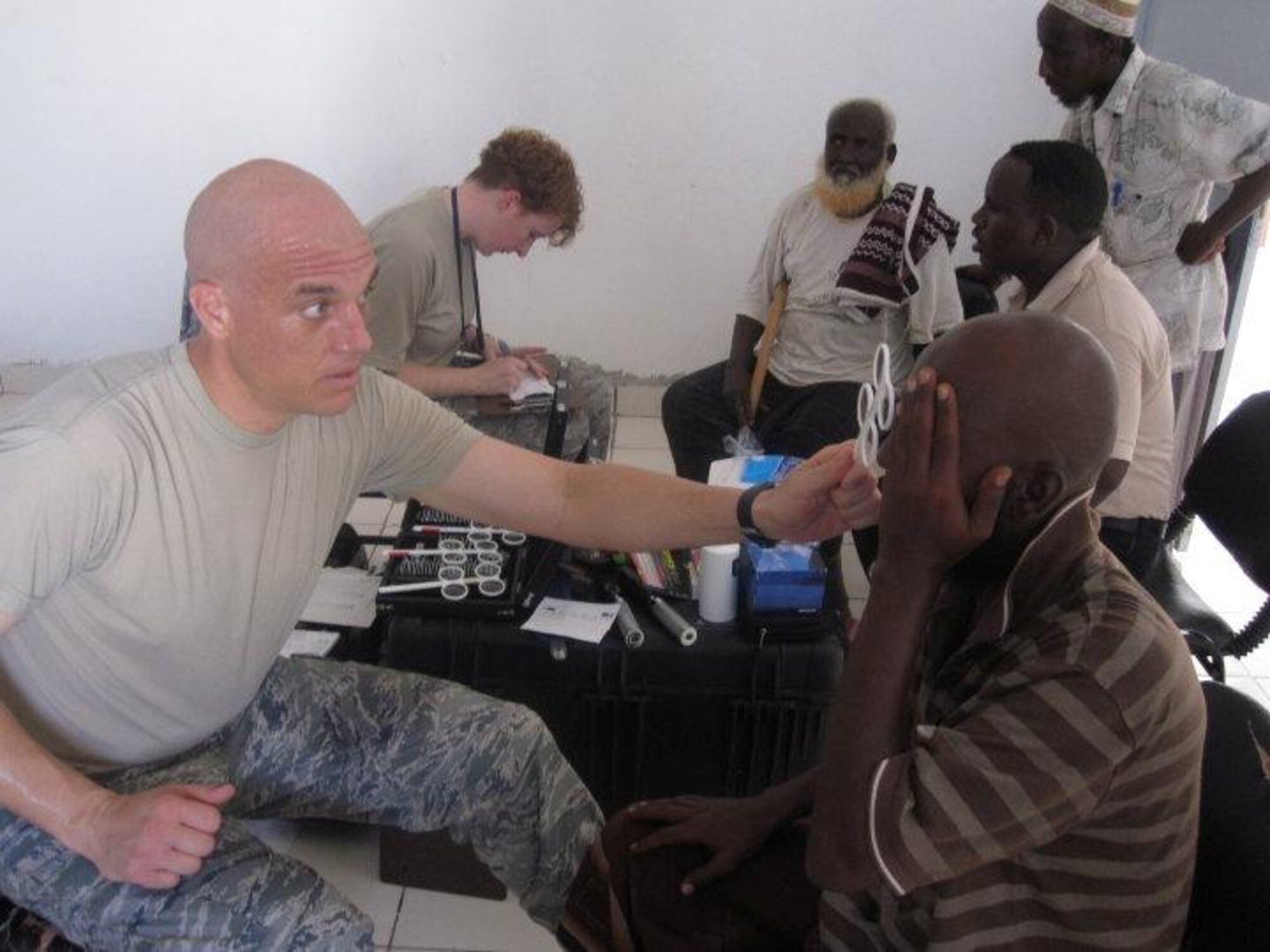 Maj. Justin Sandholm, 48th Aerospace Medicine Squadron optometrist, performs a refraction test for glasses during a Medical Civic Action Program in Djibouti, Africa, June 3. Captain Sandholm was part of a 14-member medical team that treated approximately 900 patients over two days. (U.S. Air Force photo/Tech. Sgt. Sarah Mayersky)