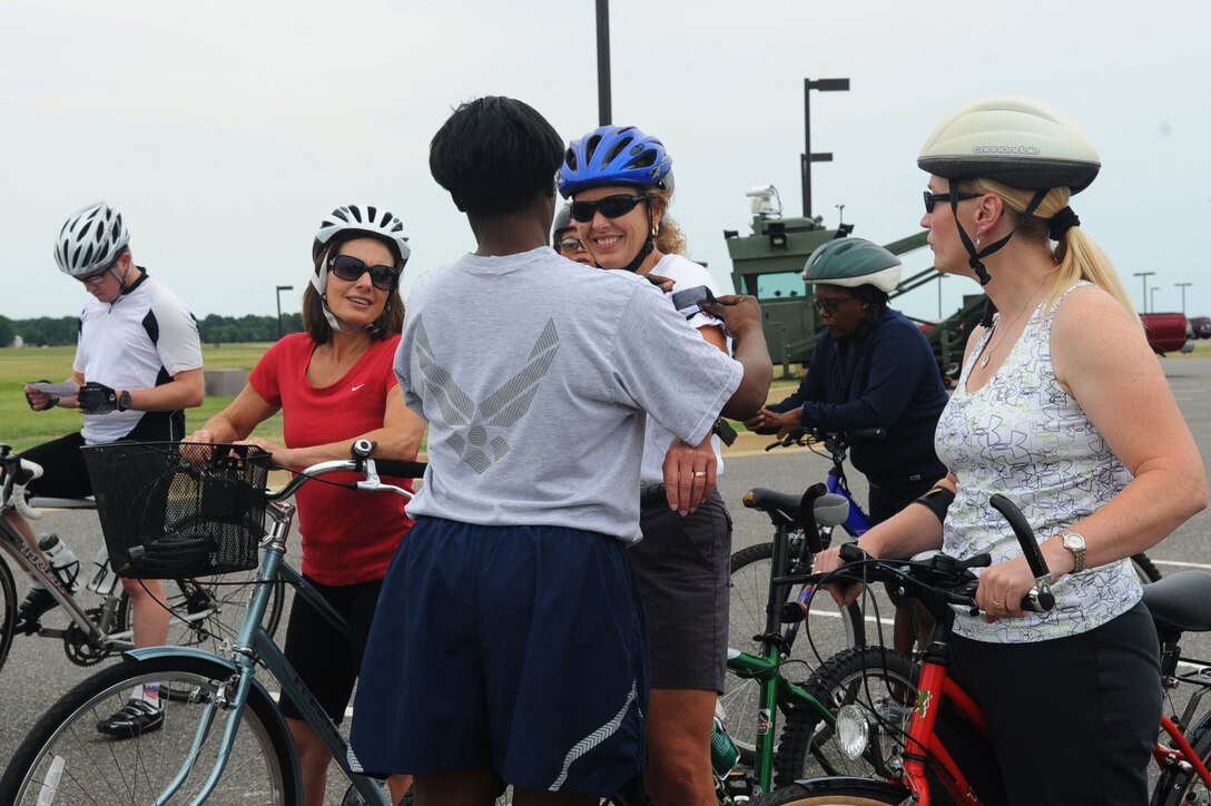LANGLEY AIR FORCE BASE, Va. -- Master Sgt. Michelle Browning, 633d Force Support Squadron, places a black arm band around a biker's arm June 30 before the Ride of Silence. Bikers wore the armband to honor someone they knew who died while riding a bicycle or motorcycle. (U.S. Air Force photo/Staff Sgt. Ashley Hawkins) (RELEASED)