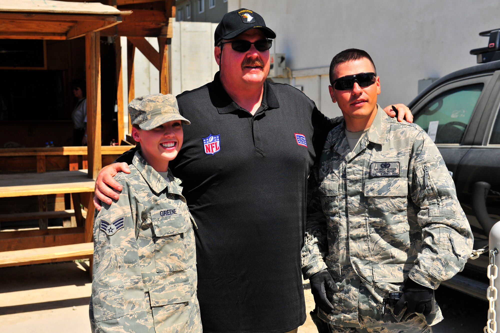 Andy Reid, head coach of the National Football League's Philadelphia Eagles, poses for pictures with Senior Airman's Stephanie Greene and Peter Garcia during a USO visit at Bagram Airfield, Afghanistan, July 4, 2010. The USO visit included head coaches from the Cincinnati Bengals, Minnesota Vikings and the Carolina Panthers. (U.S. Air Force photo/Staff Sgt. Christopher Boitz)