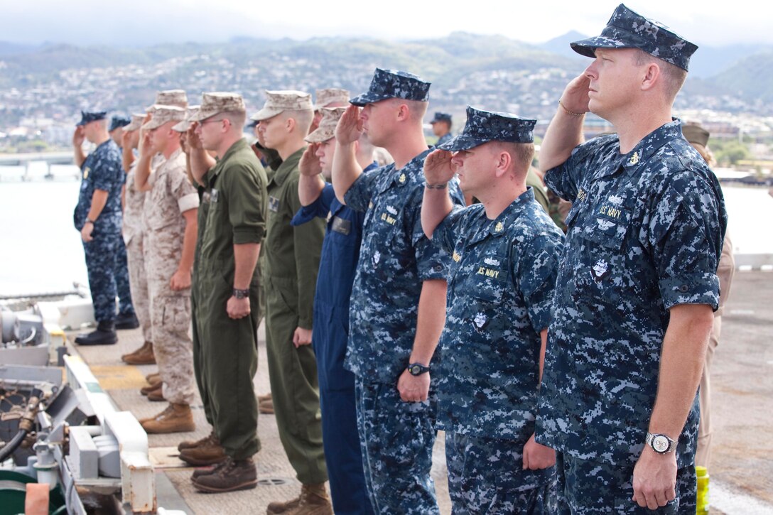 Navy Senior Chief Petty Officer Trea Osborne, Combat Systems leading chief petty officer, USS Bonhomme Richard (LHD-6), and fellow Marines and sailors assigned to the ship salute the USS Arizona Memorial as the ship departs from the Joint Base Pearl Harbor-Hickam port July 6. Carrying approximately 1,600 military personnel from Australia, Canada, Indonesia, Malaysia, Tonga and the United States, the Wasp-class amphibious assault ship is one of 34 ships participating in Exercise Rim of the Pacific 2010. As the world's largest multi-lateral maritime exercise, RIMPAC was designed to improve integration and interoperability as well as prepare forces for a wide range of potential operations and missions.
