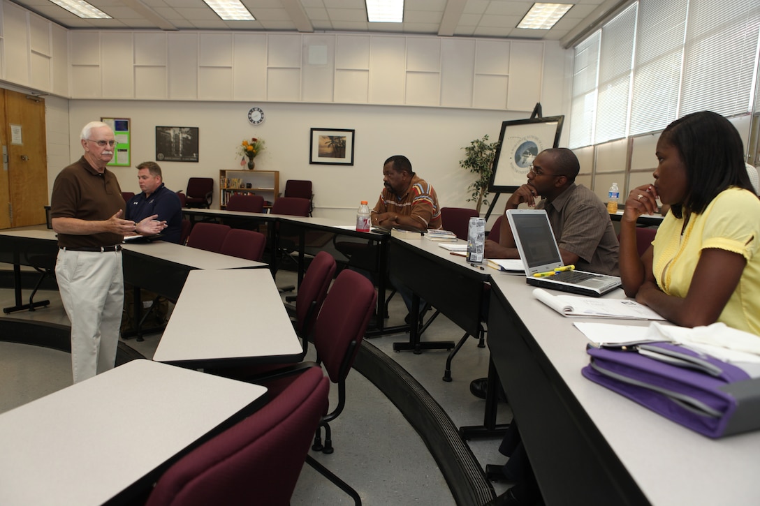 Dr. Robert Bender (left), a Webster University management professor, teaches a graduate-level course at the Base Education Center aboard Marine Corps Base Camp Lejeune, recently.  More than 500 service members, families, Department of Defense civilians and military retirees are pursuing their master’s degrees by taking courses in the classroom and online.
