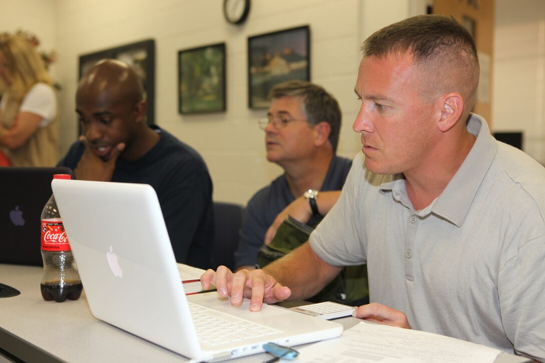 1st Lt. Ryan Kohrig (right), pay officer in charge at the disbursing office, Company A, Headquarters and Support Battalion, Marine Corps Base Camp Lejeune, and a Webster University graduate student, works on his computer during a management class taught at the Base Education Center, recently.  More than 500 service members, families, Department of Defense civilians and military retirees are pursuing their master’s degrees by taking courses in the classroom and online.