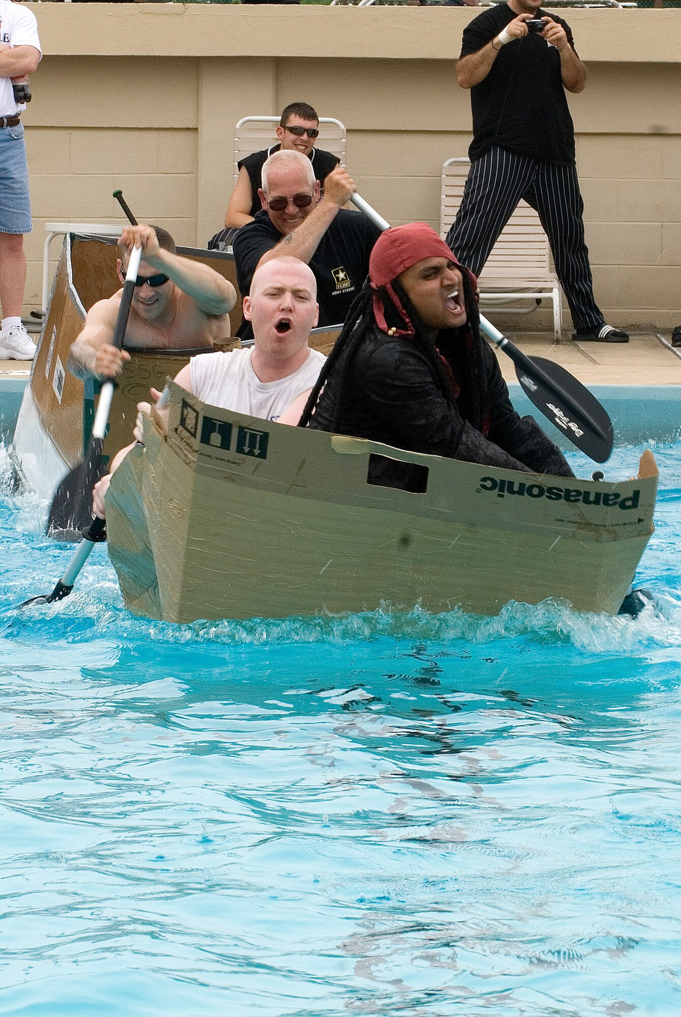KUNSAN AIR BASE, Republic of Korea --   2nd Lt. Tabish Khan and 1st Lt. Dan Winn, both of the 8th Operations Group, struggle to stay ahead of another team during the cardboard boat race July 4 at the base pool. In addition to the boat race, there was also a five kilometer run, firefighter relay race, a free barbecue and more, culminating in a fireworks show at the end of the night. (U.S. Air Force photo/Staff Sgt. Jonathan Pomeroy)