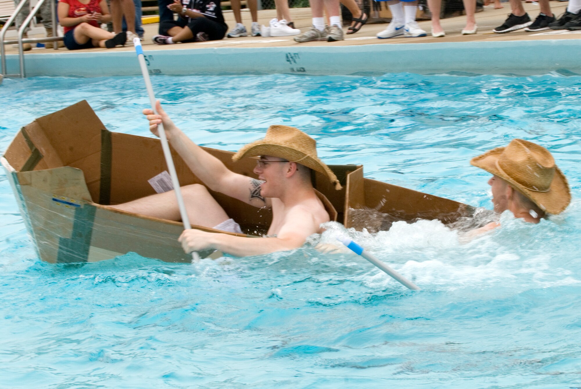KUNSAN AIR BASE, Republic of Korea -- Senior Airman Woodrow Walkup and Airman 1st Class Jared Shiftman, both of the 8th Maintenance Squadron, fight to stay afloat during the cardboard boat race July 4 at the base pool. In addition to the boat race, there was also a five kilometer run, firefighter relay race, a free barbecue and more, culminating in a fireworks show at the end of the night.(U.S. Air Force photo/Staff Sgt. Jonathan Pomeroy)