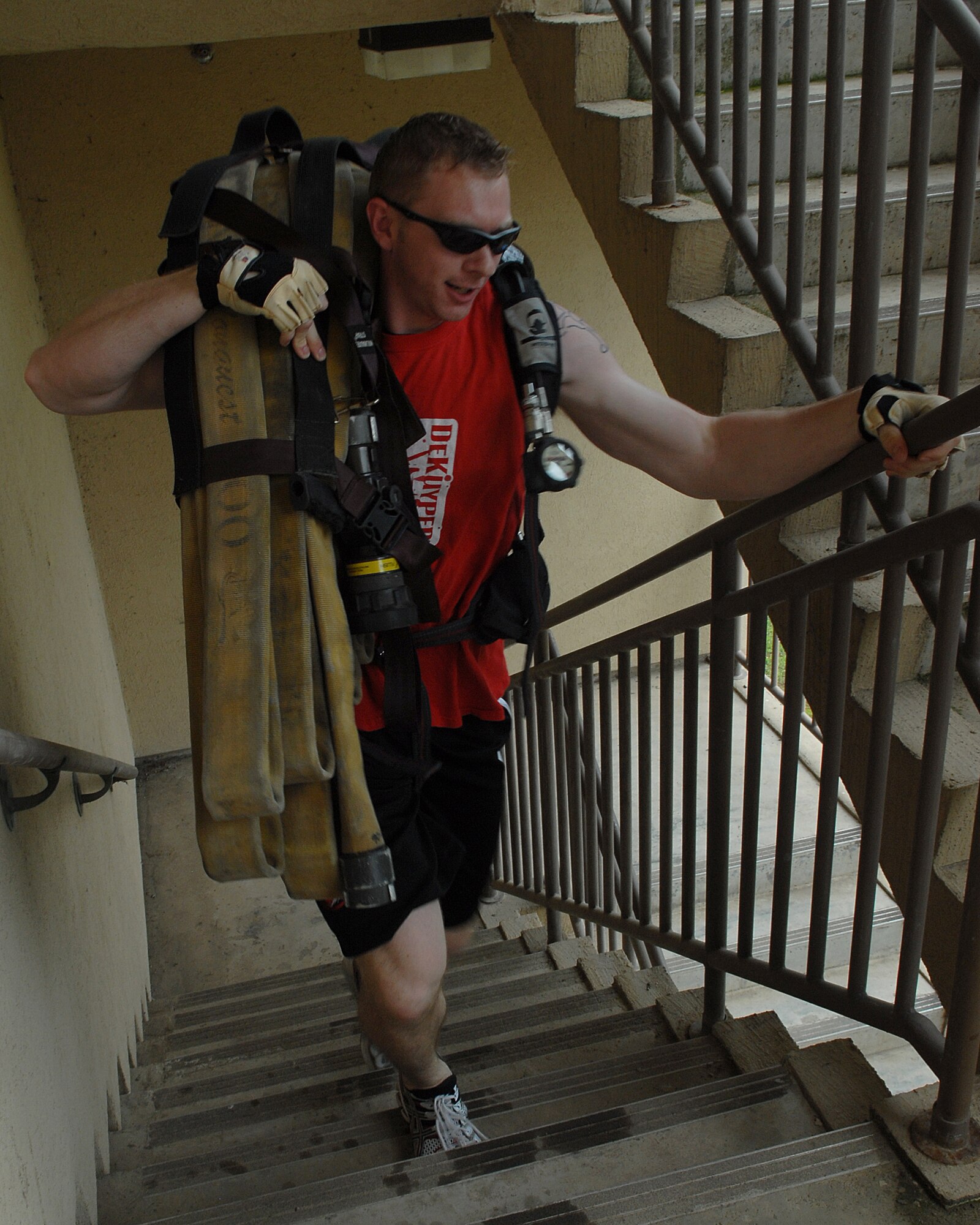 KUNSAN AIR BASE, Republic of Korea -- Staff Sgt. Adam Cook, 8th Operation Support Squadron, runs a fire hose up three flights of stairs during a firefighter relay race here July 4. Sergeant Cook was part of a three-man team that completed the 10-event race with a time of 3 minutes and 14 seconds. In addition to the relay race, there was also a five kilometer run, cardboard boat race, a free barbecue and more, culminating in a fireworks show at the end of the night. (U.S. Air Force photo/Senior Airman Roy Lynch)