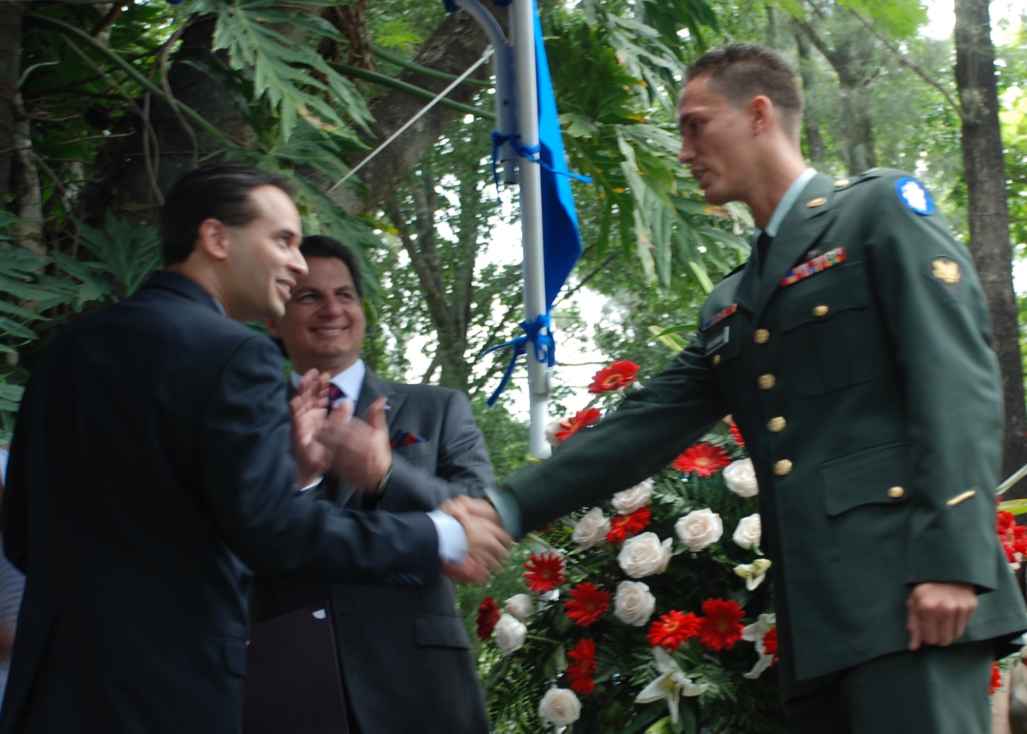 Spc. Eniol Abreusarmiento, a helicopter mechanic and crew chief in the 1-228th Aviation Regiment, Soto Cano Air Base, Honduras, shakes hands with Emigdio Martinez, the field office director for the Office of Citizenship and Immigration Services, after taking the naturalization oath during a ceremony in Tegucigalpa July 2. Specialist Abreusarmiento, who was born in Cuba, became a U.S. citizen at an Independence Day celebration hosted by U.S. Ambassador to Honduras Hugo Llorens and attended by Honduran President Porfirio Lobo. (U.S. Air Force photo by 1st Lt. Jen Richard)