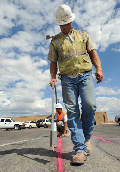 HOLLOMAN AIR FORCE BASE, N.M. -- Eric McFarland, a foreman with the Mesa Verde Enterprises Inc., uses a tag stick to mark lines for the construction of a new curb near the Base Commissary June 29, 2010. Before adding a new curbside, a bullnose is drawn to create a concrete bedded edge. Mesa Verde Enterprises Inc. employees will be working on New Mexico Avenue for the next five months in an effort to improve the infrastructure at Holloman. (U.S. Air Force photo by Senior Airman Veronica Stamps / Released)