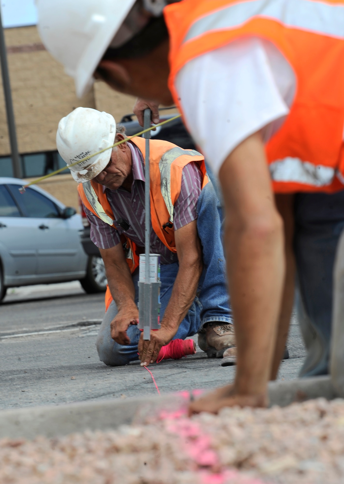HOLLOMAN AIR FORCE BASE, N.M. -- Alex Moya and Steve Wimsatt, both employees from the Mesa Verde Enterprises Inc., work together to create a bullnose -- a method used for creating a concrete bedded edge -- to expand the curbs leading into the Base Commissary June 29, 2010. Costing approximately $1.1 million, the road construction project is an effort to improve the infrastructure at Holloman. (U.S. Air Force photo by Senior Airman Veronica Stamps / Released)