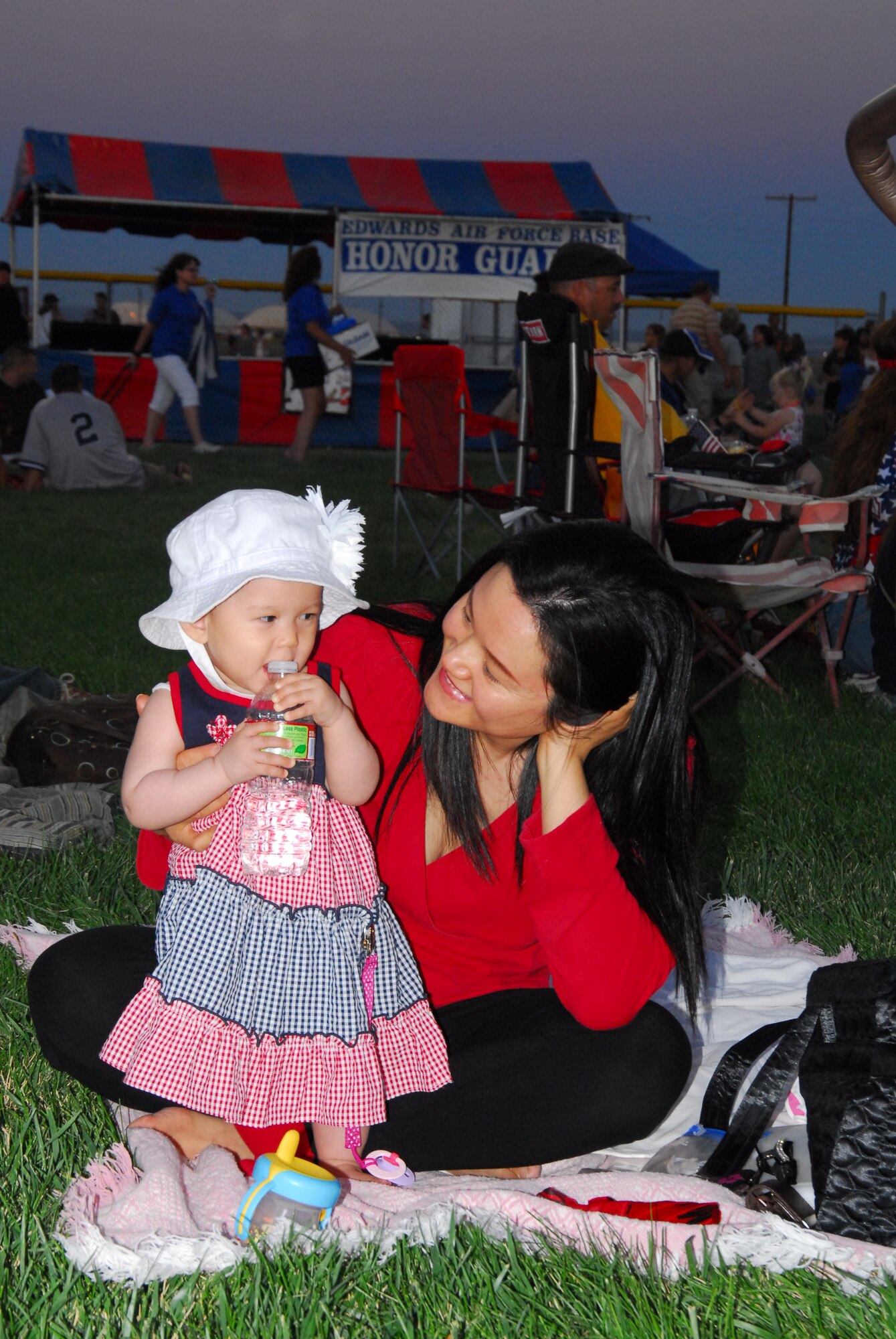 This nine-month-old, dressed in her best patriotic attire, Esther brought her mother, Michelle, to Summer Bash 20-10.  She told her mother how important it was to stay hydrated, but needed a little help getting the cap off this bottle.  (Air Force photograph by Stephen K. Robinson)