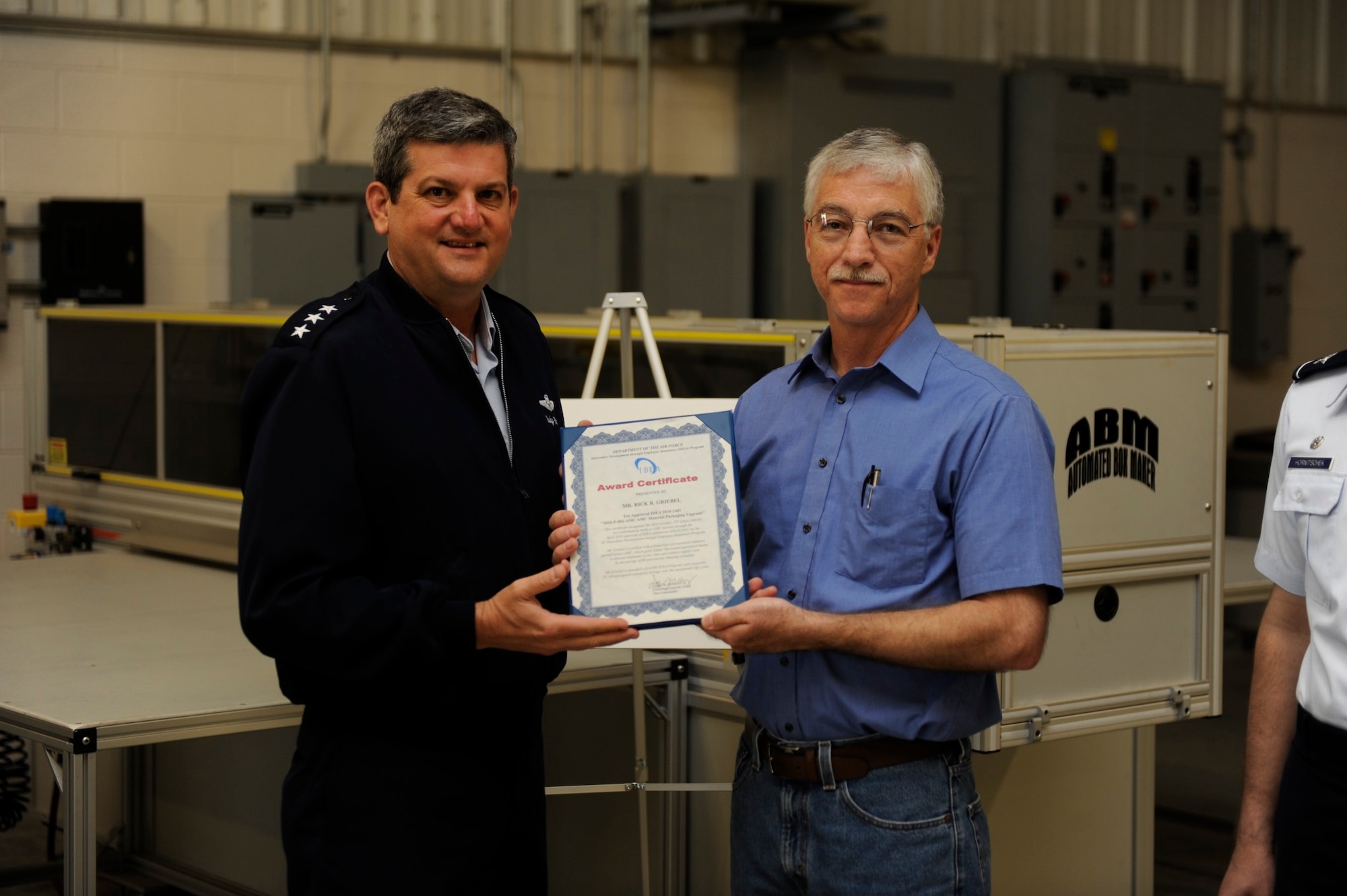 SCOTT AIR FORCE BASE, Ill. -- Lt. Gen. Rusty Findley, Air Mobility Command vice commander, presents Rick Griebel with an IDEA award certificate.  Mr. Griebel introduced a box-making machine and shredder into 375th Logistics Readiness Squadron operations, saving the squadron time and money. (U.S. Air Force photo by Senior Airman Ryan Crane)
