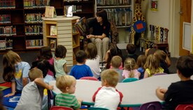 Sarah Sherrill reads a volcano book to children during the summer reading program at the base library June 30, 2010 on Joint Base Charleston, S.C. The Summer Reading program lasts six weeks, from June to July, offering an interactive program designed to encourage children to read. Miss Sherrill is a library technician in charge of programs and special events at the base library. (U.S. Air Force photo/Senior Airman Timothy Taylor)