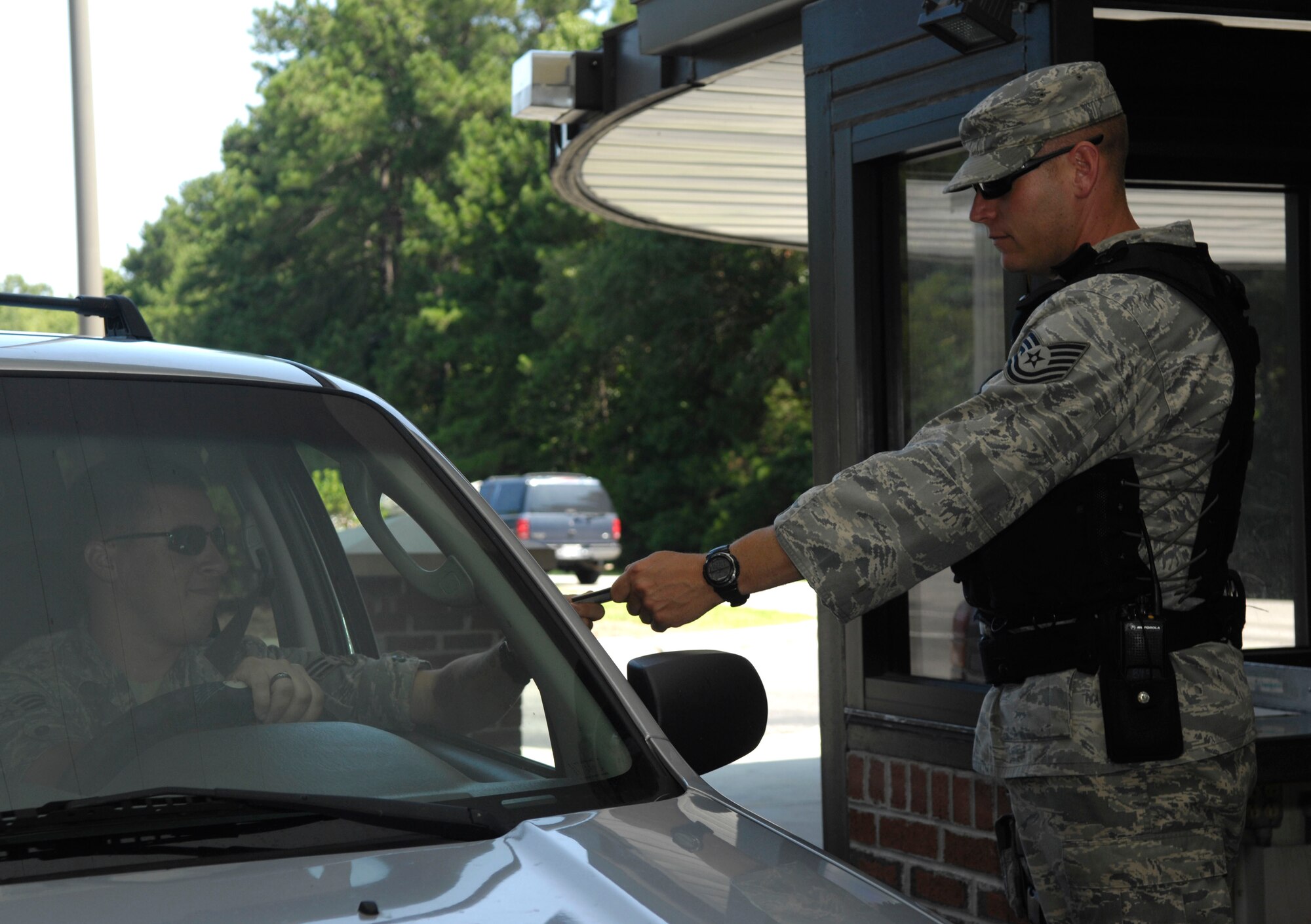 Tech. Sgt. Brian Saylors checks an identification card at the back gate on Joint Base Charleston, S.C., July 7, 2010. Sergeant Saylors is well known around the base for bellowing his trademark phrase ?motivated!? whenever anyone asks him how he is. Sergeant Saylors is not your typical Airman, he served five and a half years in the Marine Corps as a reconnaissance Marine during the war in Bosnia before making the transition to the Air Force. As a civilian Sergeant Saylors works as a paramedic at Berkley County Hospital. Despite his hard exterior, Sergeant Saylors said that he enjoyed helping people and saving lives.  During his one year tour as a security forces augmentee Sergeant Saylors has refined himself as a noncommissioned officer and stated that he wants to be known for his professionalism and dedication to the military. Sergeant Saylors is a fire protection journeyman with the 315th Civil Engineer Squadron. (U.S. Air Force Photo/Airman 1st Class Lauren Main)
