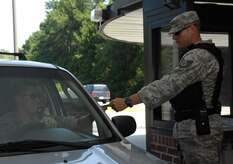 Tech. Sgt. Brian Saylors checks an identification card at the back gate on Joint Base Charleston, S.C., July 7, 2010. Sergeant Saylors is well known around the base for bellowing his trademark phrase "motivated!" whenever anyone asks him how he is. Sergeant Saylors is not your typical Airman, he served five and a half years in the Marine Corps as a reconnaissance Marine during the war in Bosnia before making the transition to the Air Force. As a civilian Sergeant Saylors works as a paramedic at Berkley County Hospital. Despite his hard exterior, Sergeant Saylors said that he enjoyed helping people and saving lives. During his one year tour as a security forces augmentee Sergeant Saylors has refined himself as a noncommissioned officer and stated that he wants to be known for his professionalism and dedication to the military. Sergeant Saylors is a fire protection journeyman with the 315th Civil Engineer Squadron. (U.S. Air Force Photo/Airman 1st Class Lauren Main) 