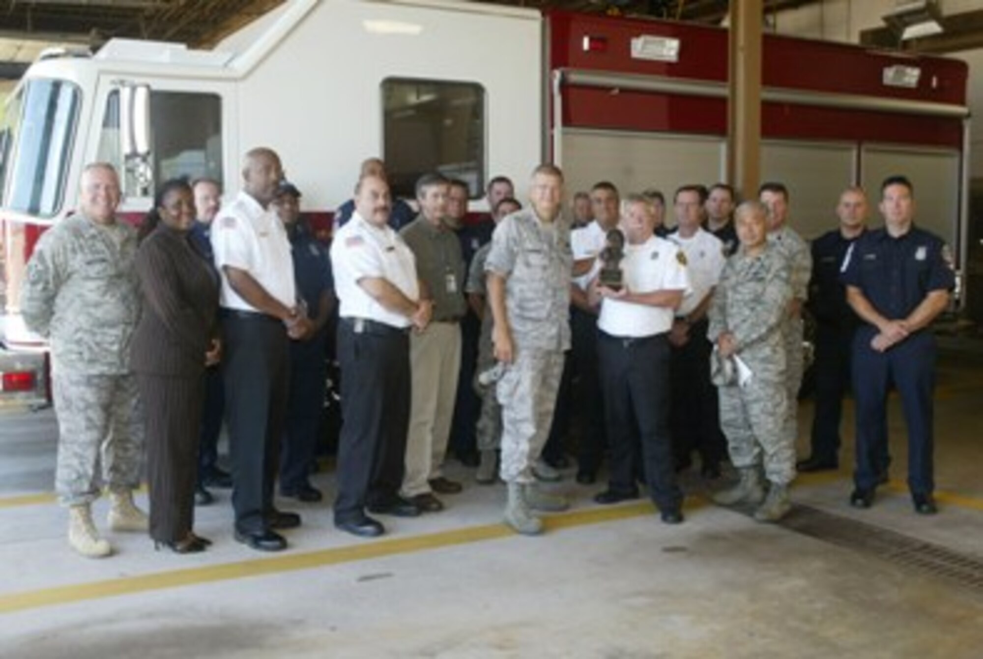 Col. Timothy E. Tarchick, 94th Airlift Wing commander, honors Fire Chief John R. Hicks and members of the 94th Civil Engineer Squadron Base Fire Department July 7.  They were chosen for the annual Air Reserve Command’s Fire Department of the Year, Medium Fire Department Category, covering 2009.