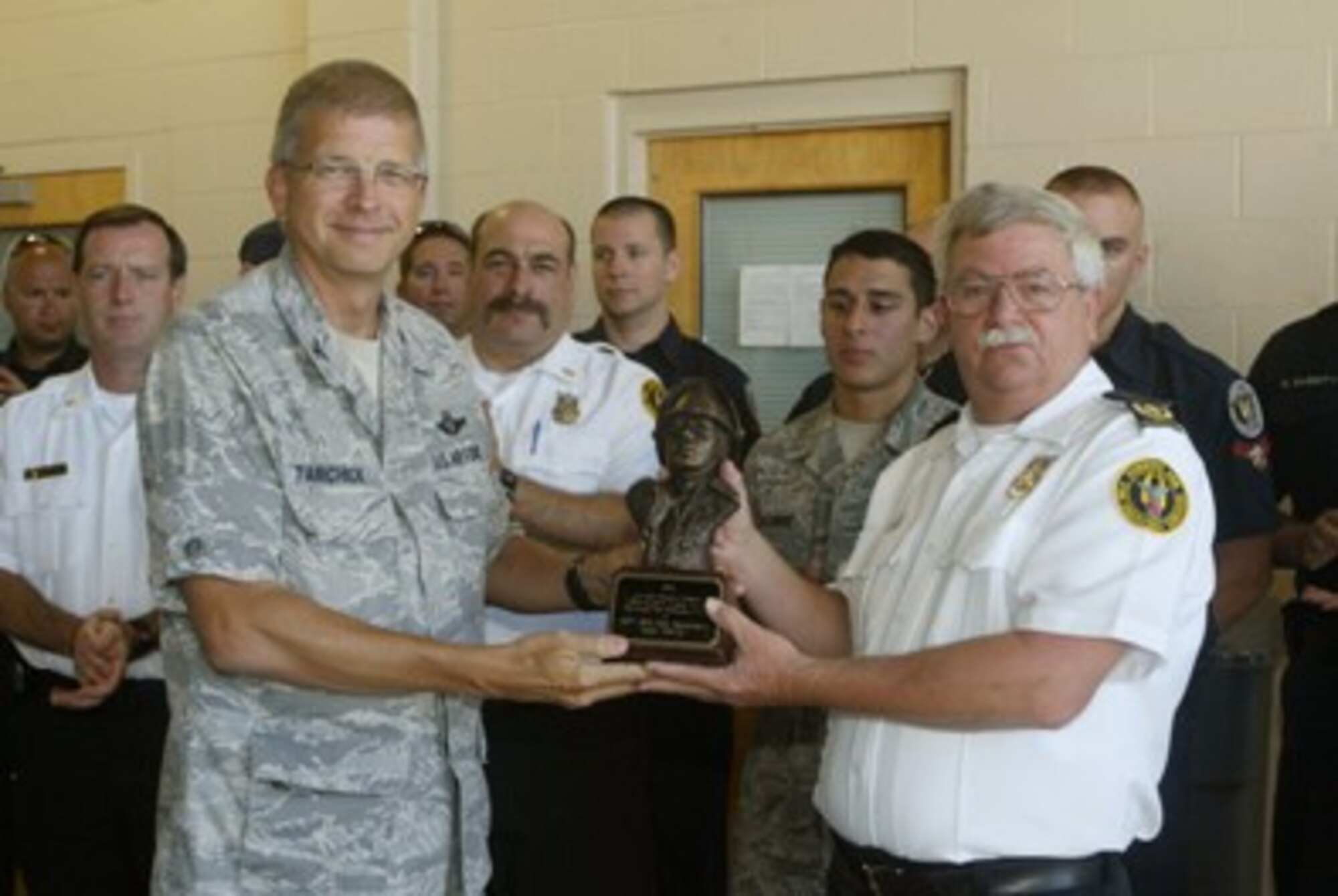 Col. Timothy E. Tarchick, 94th Airlift Wing commander, honors Fire Chief John R. Hicks and members of the 94th Civil Engineer Squadron Base Fire Department July 7.  They were chosen for the annual Air Reserve Command’s Fire Department of the Year, Medium Fire Department Category, covering 2009.