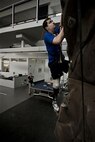 Conquering the rock climbing wall at the Center for the Intrepid is just one of the exercises physical therapist Alicia White (holding the safety rope) has McGuire perform. The rehabilitation therapy helps the lieutenant get used to the prosthetic he received after having his lower right leg amputated following a boating mishap last summer. (TSgt Samuel Bendet)
