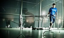 Using a bungee cord to force him to shift his weight to his prosthesis, 1st Lt. Ryan McGuire goes through demanding physical therapy at the Center for the Intrepid in BAMC, San Antonio. Inset, McGuire competes in the 1,500-meter run at the inaugural Warrior Games in Colorado May 14.(TSgt Samuel Bendet)