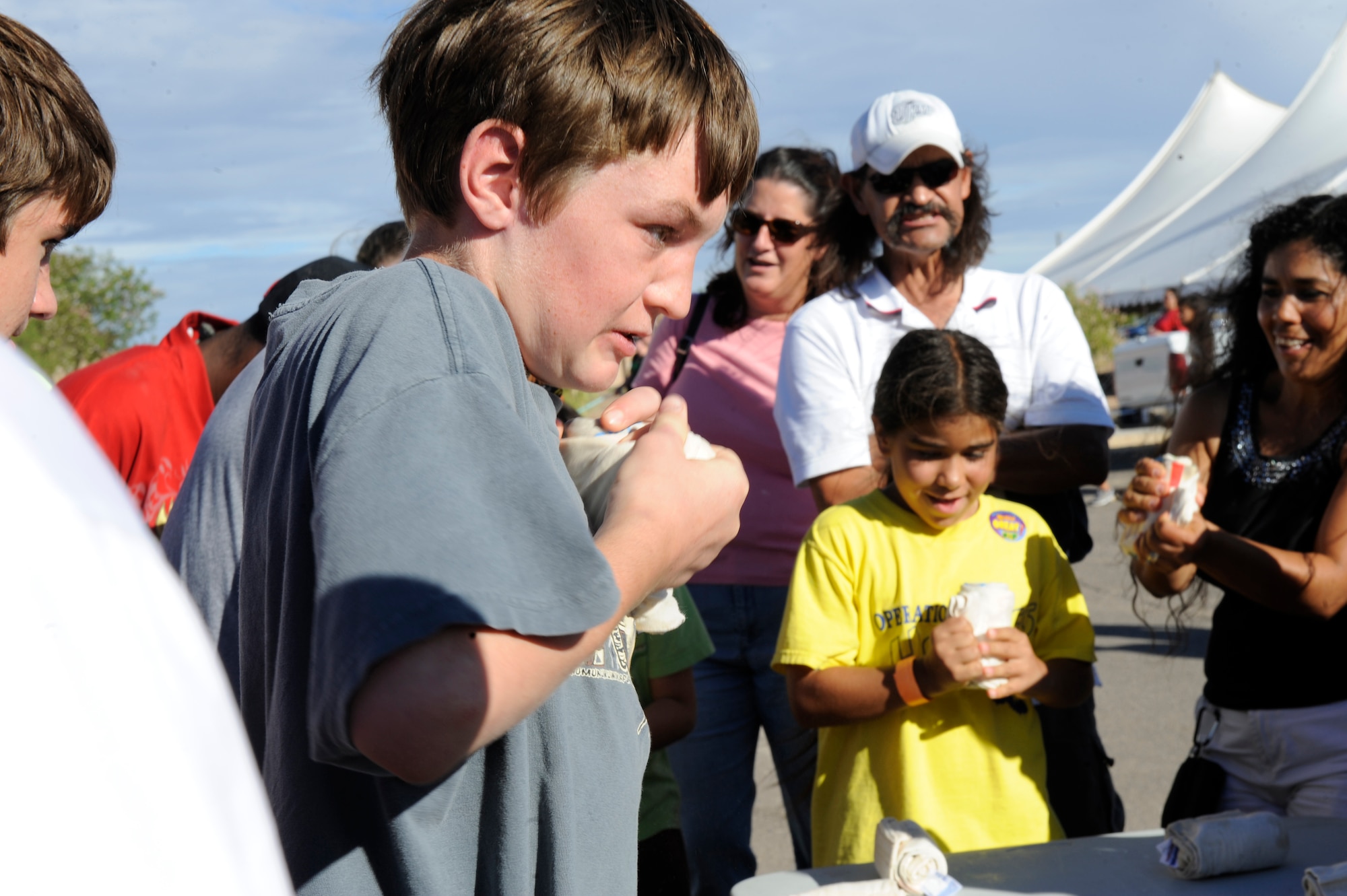HOLLOMAN AIR FORCE BASE, N.M. -- Samuel Irvine, a military dependant, attempts to unravel a frozen t-shirt during a contest at the Fourth of July Block Party in the Domenici Fitness and Sports Center parking lot July 2, 2010.  Many other activities, such as musical chairs, hula hooping and a water balloon fight contributed to the event. (U.S. Air Force photo by Airman 1st Class Eileen Payne / Released)