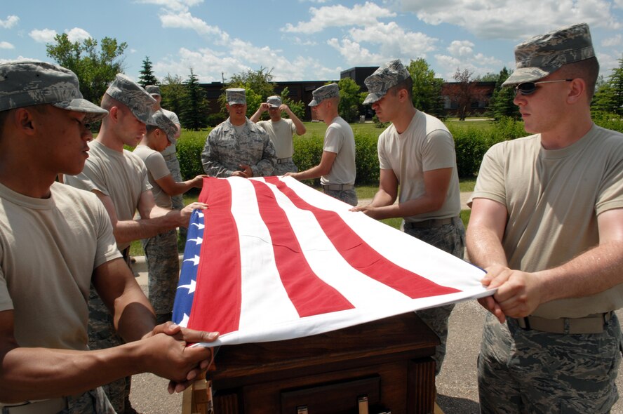 MINOT AIR FORCE BASE, N.D. -- Airman 1st Class Justin Baker, U.S. Air Force Honor Guard instructor, trains Airmen on proper procedures of a six-man flag fold here June 24. The U.S. Air Force Honor Guard’s Mobile Training Team traveled to Minot AFB to educate and train Airmen on basic protocol, honors and ceremonies, as well as create certified trainers for their units. (U.S. Air Force photo by Senior Airman Michael J. Veloz)
