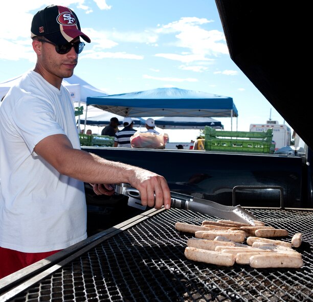 HOLLOMAN AIR FORCE BASE, N.M. -- A volunteer prepares brats on the grill to serve to people at the Fourth of July celebration, July 2, 2010. Many organizations from around base offered different types of concessions to raise money for their respective booster clubs during the celebration. (U.S. Air Force photo by Senior Airman DeAndre Curtiss / Released)