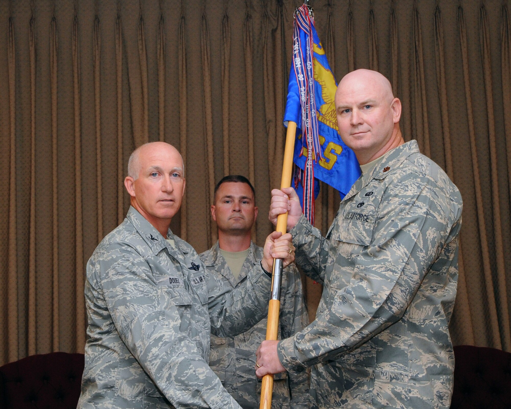Maj. Robert Reinhard recieves the 319th Force Support Squadron guideon from Col. Joseph Douez, 319th Mission Support Group commander during an assumption of command ceremony July 7, 2010. (U.S. Air Force photo/Tech. Sgt. Johnny Saldivar)