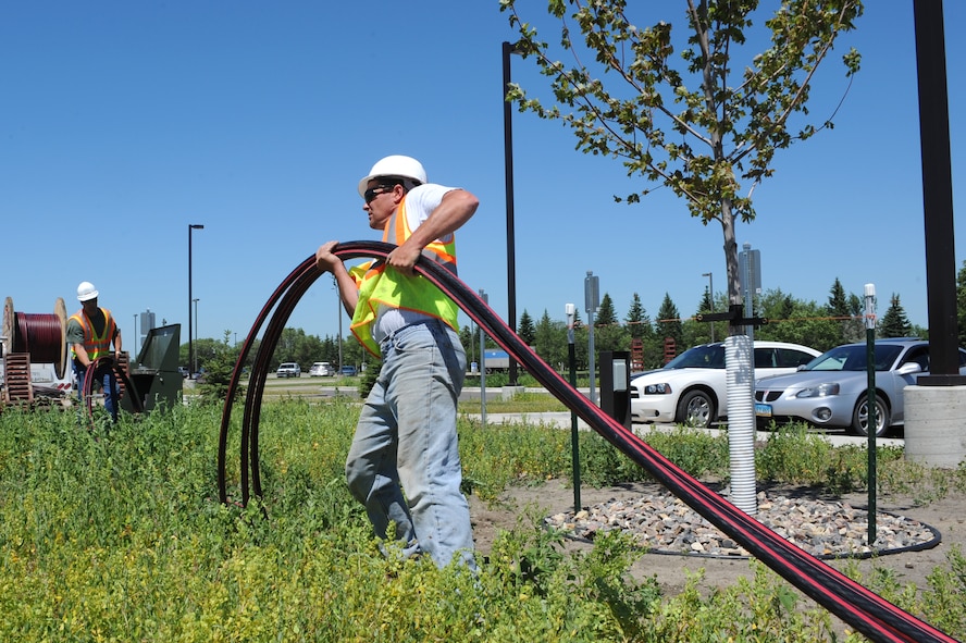 MINOT AIR FORCE BASE, N.D -- Todd Awalt, construction worker, pulls a high voltage cord toward a transformer to supply power to the new dormitory here June 24. The new dorm will consist of 168 rooms and will heighten Airmen’s morale, allowing them to better accomplish the base’s mission. (U.S. Air Force photo by Airman 1st Class Aaron-Forrest Wainwright) 