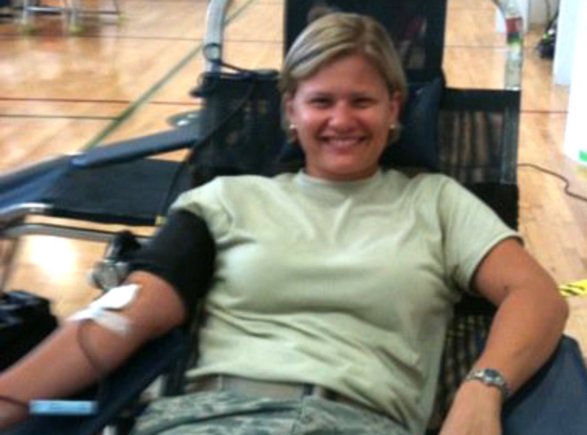 U.S. Air Force Master Sgt. Elizabeth Holzbaur, an auto flight instrument and navigation craftsman with the 315th Aircraft Maintenance Squadron, was all smiles for a mobile upload to facebook while she donated blood to the American Red Cross at the Sports and Fitness Center June 23, 2010, at Charleston Air Force Base, S.C (U.S. Air Force photo/Tech. Sgt. Mike Kiker)