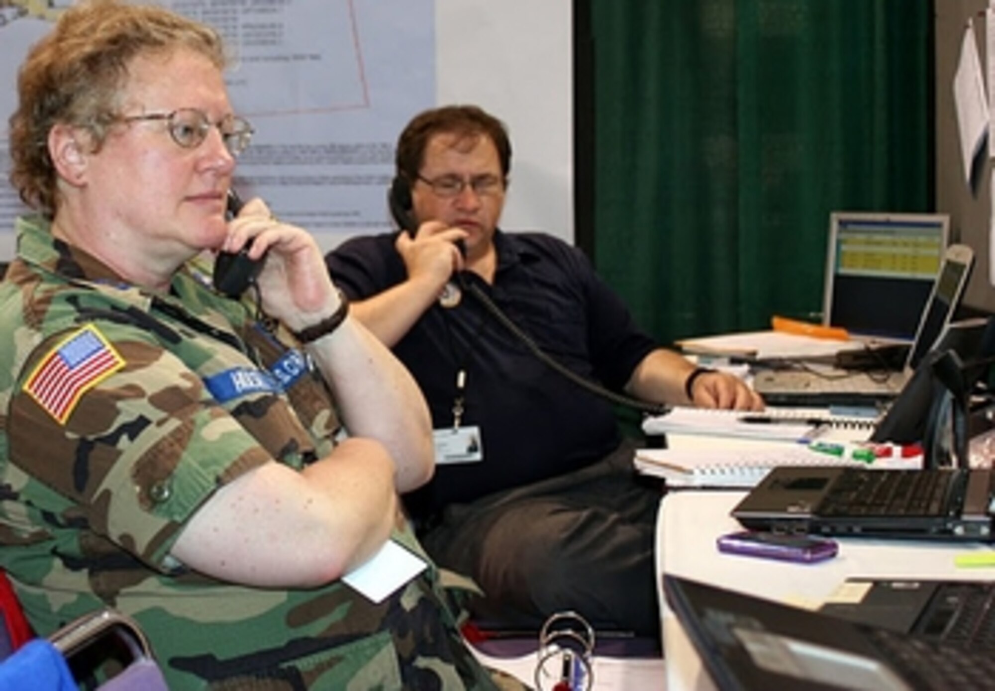 Capt. Jan Hulsey (left), from CAP’s National Operations Center, and Maj. David Hester, a CAP incident commander and the Alabama Wing’s director of communications, work the phone lines at CAP’s “Air Ops” desk in the command center. Photos by Capt. Phil Norris