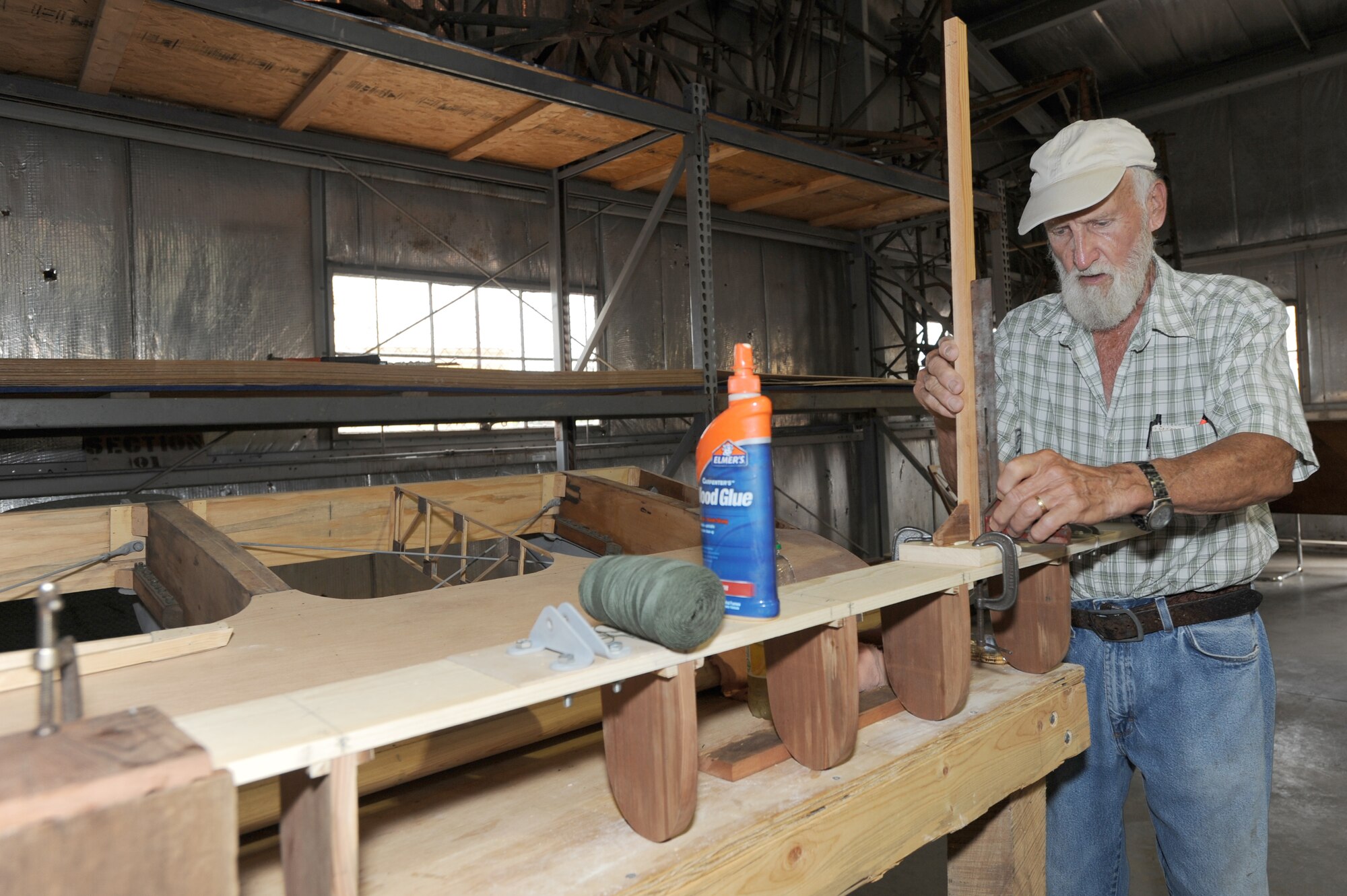 WHITEMAN AIR FORCE BASE, Mo. - Robert Rainey, Waco glider restoration project volunteer, works on a support section of the stabilizer, preparing it to receive its ribs, July 7. Workers spend a great deal of time looking over the old technical orders on the plane to ensure it is rebuilt to the correct specifications.(U.S. Air Force photo/ Senior Airman Carlin Leslie)(Released)
