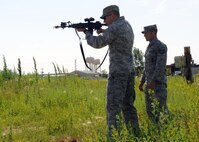 MINOT AIR FORCE BASE, N.D. -- Technical Sgt. Paul Mastrony, 91st Security Support Squadron security forces instructor, watches as U.S. Air Force Academy Cadet Nathan Seibt prepares to engage a target during a Laser Collective Combat Advanced Training System session here June 24.  The LCCATS is a simulator that allows the shooter to be placed in a shoot, no-shoot scenarios. (U.S. Air Force photo by Staff Sgt. Keith Ballard)