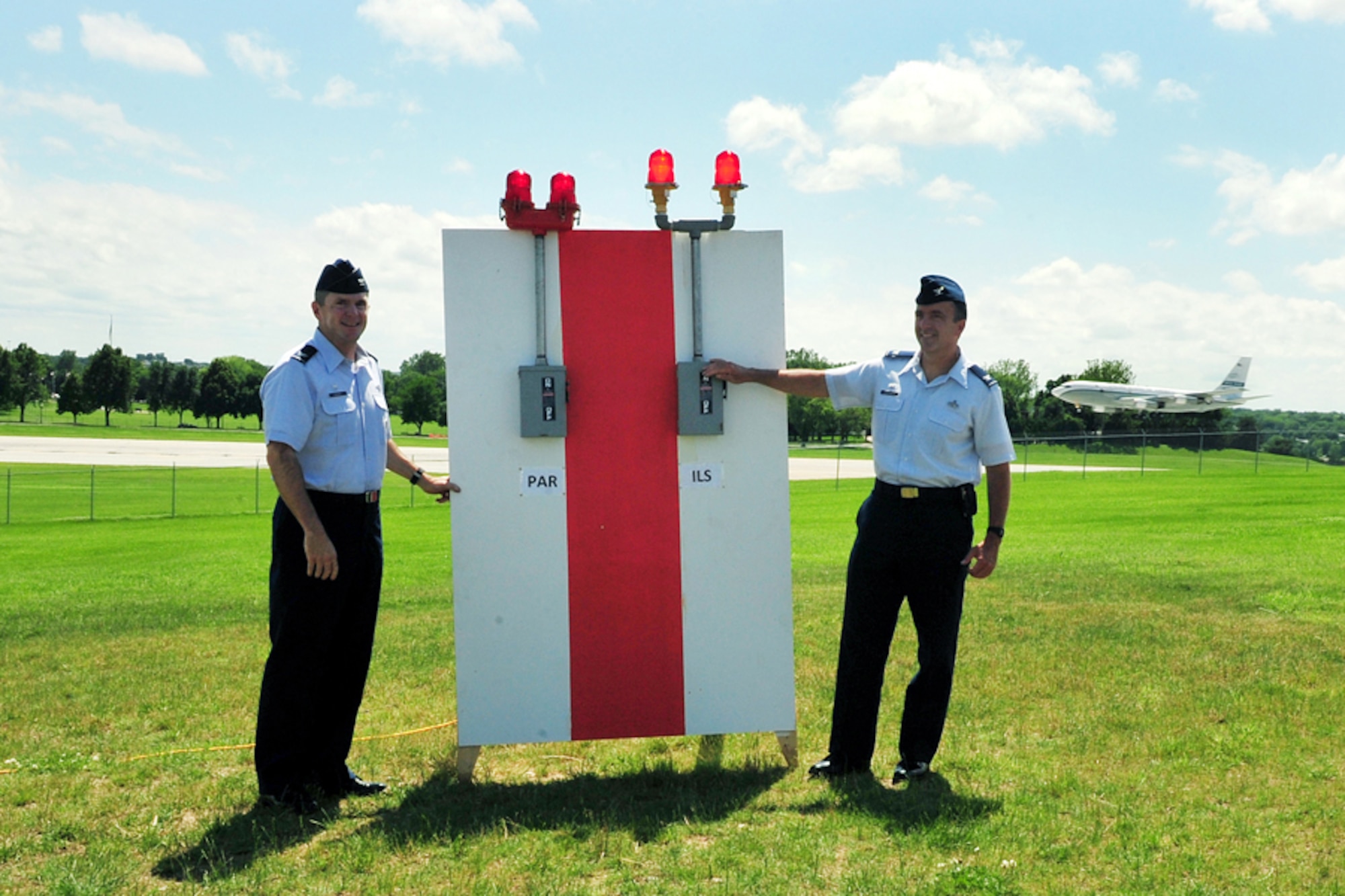 OFFUTT AIR FORCE BASE, Neb. - During a special ceremony June 21, 55th Communications Group Commander Col. Dennis Lisherness (right) threw a symbolic switch to signify the commissioning of the new Instrument Landing System. Moments earlier, 55th Operations Group Commander Col. John Hansen threw another switch to turn off the outdated Precision Approach Radar system. Offutt has used the PAR for the last 14 years, but growing rapair costs and manpower requirements made the outdated system ineffective. U.S. Air Force photo by Charles Haymond