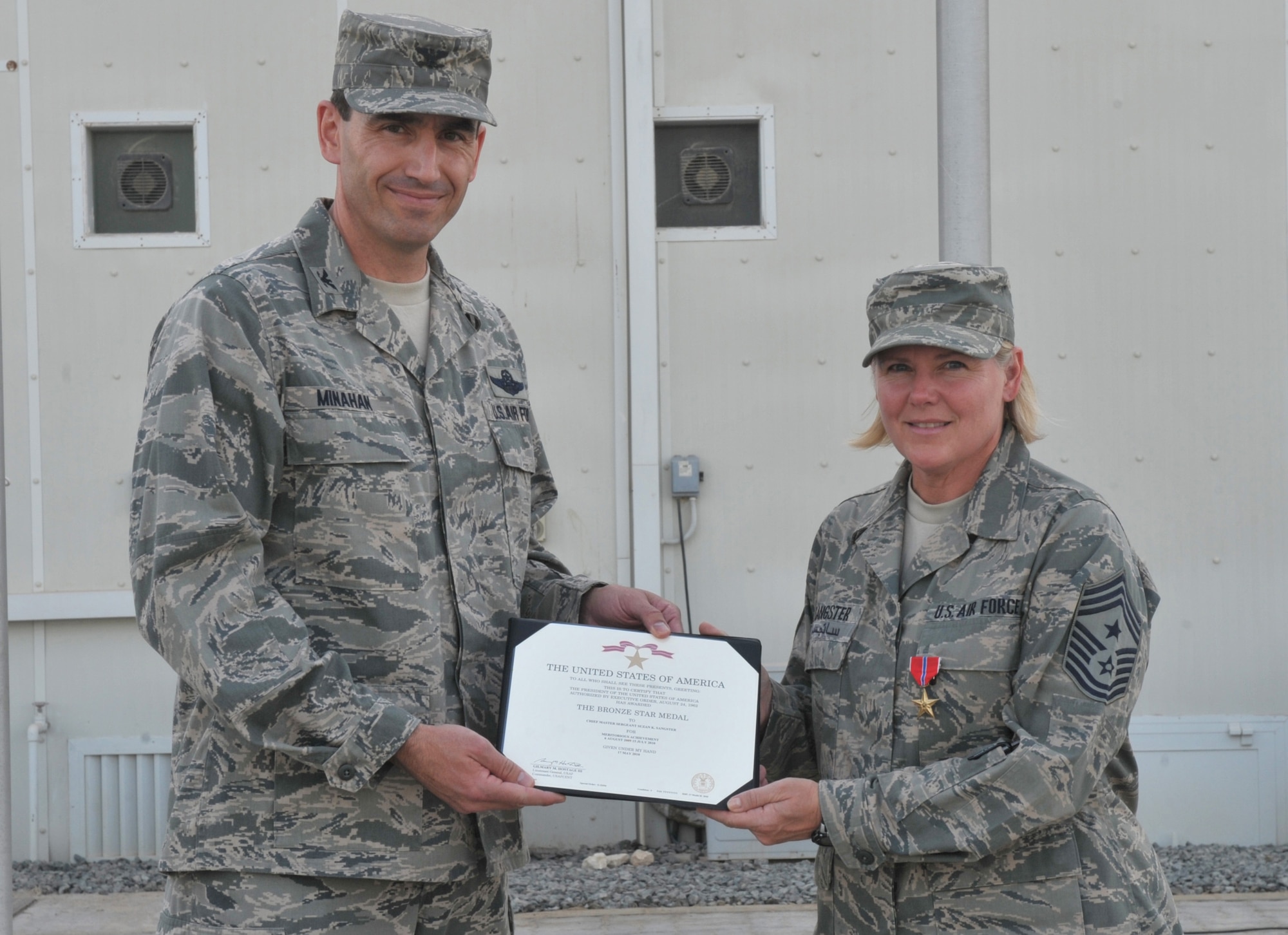 380th Air Expeditionary Command Chief Master Sgt. Suzan Sangster poses with 380th AEW commander then Col. Mike Minahan, July 2., after receiving her Bronze Star here. The chief served a year here and is set to be replaced by Command Chief Master Sergeant Timothy Horn. General Minahan received his first star the day after this photo was taken. (U.S. Air Force photo/Tech. Sgt. April Wickes)