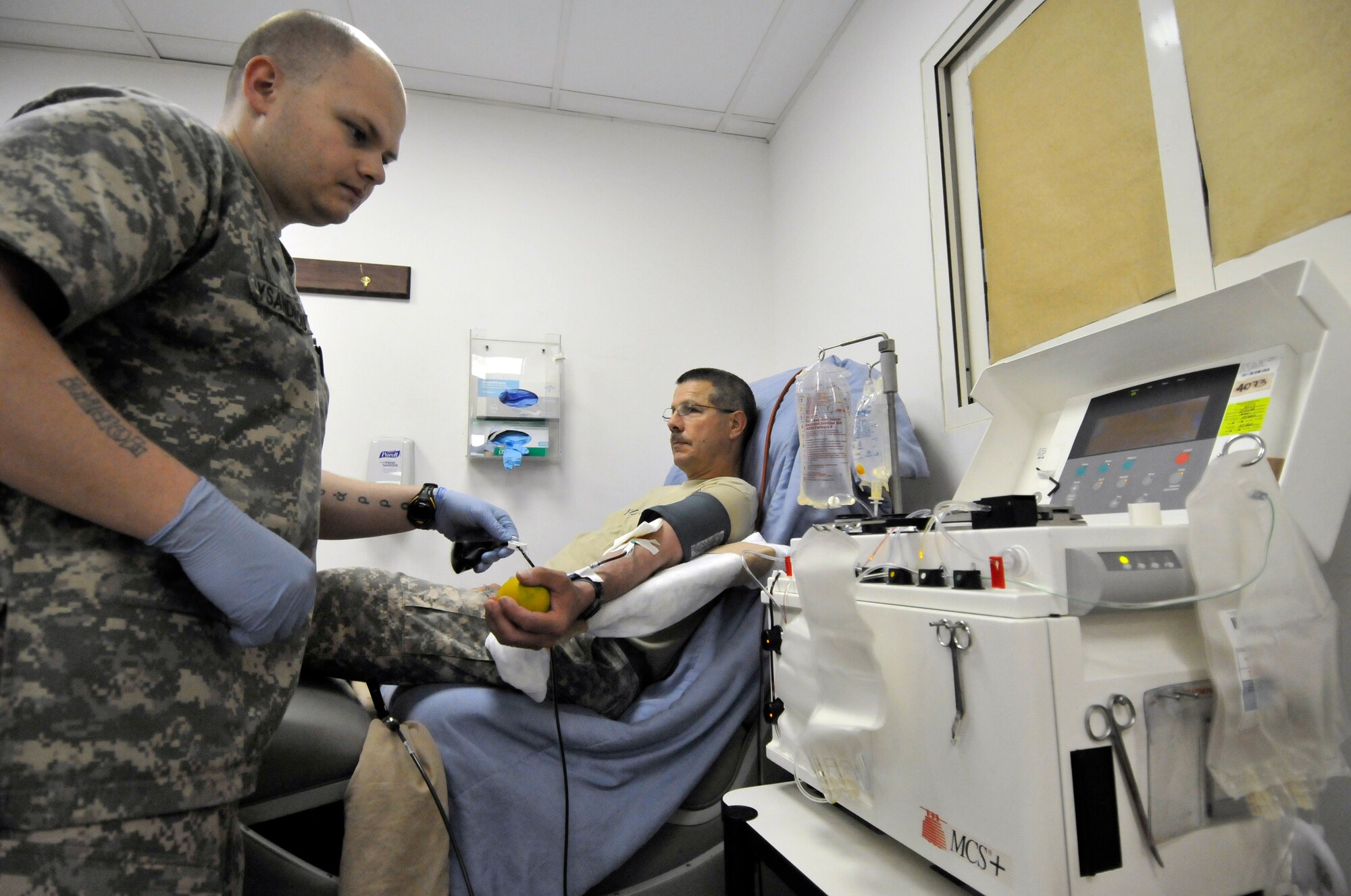 Army Spec. James Lysandrou, 932nd Blood Support Detachment aphaeresis lab technician, watches as blood flows from Army Chief Warrant Officer 2 Norman Young, 15th Military Intelligence Battalion accreditation officer in charge, into the platelet separator July 5, 2010, Joint Base Balad, Iraq. A patient’s platelet count determines the time spent in the lab. Specialist Lysandrou is deployed from Fort Hood, Texas, and Warrant Officer Young is deployed from Fort Lewis, Wash. (U.S. Air Force photo/Staff Sgt. Phillip Butterfield)