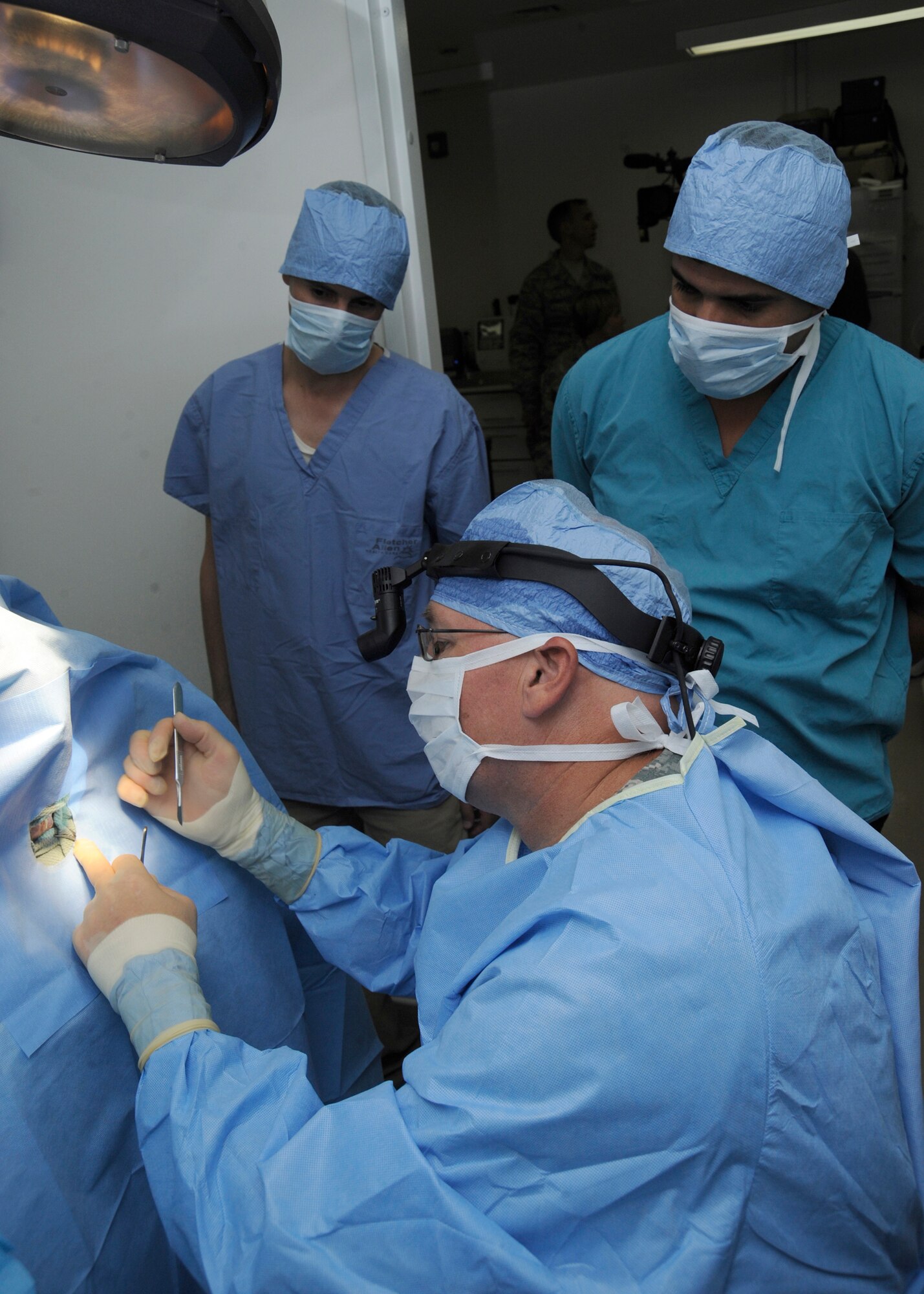 Captain Christopher Gorencel ,  248th Medical Detachment Talil Team Echo veterinarian, removes a tumor from a patient with two Baghdad Police College Canine Directorate veterinarians sitting in attendance  at Joint Base Balad, Iraq, June 28, 2010. The U.S. Army veterinarians at Balad trained two local veterinarians on the ins-and-outs of small animal medicine from June 28 to July 2. (U.S. Air Force photo/ Senior Airman Matt Coleman-Foster)