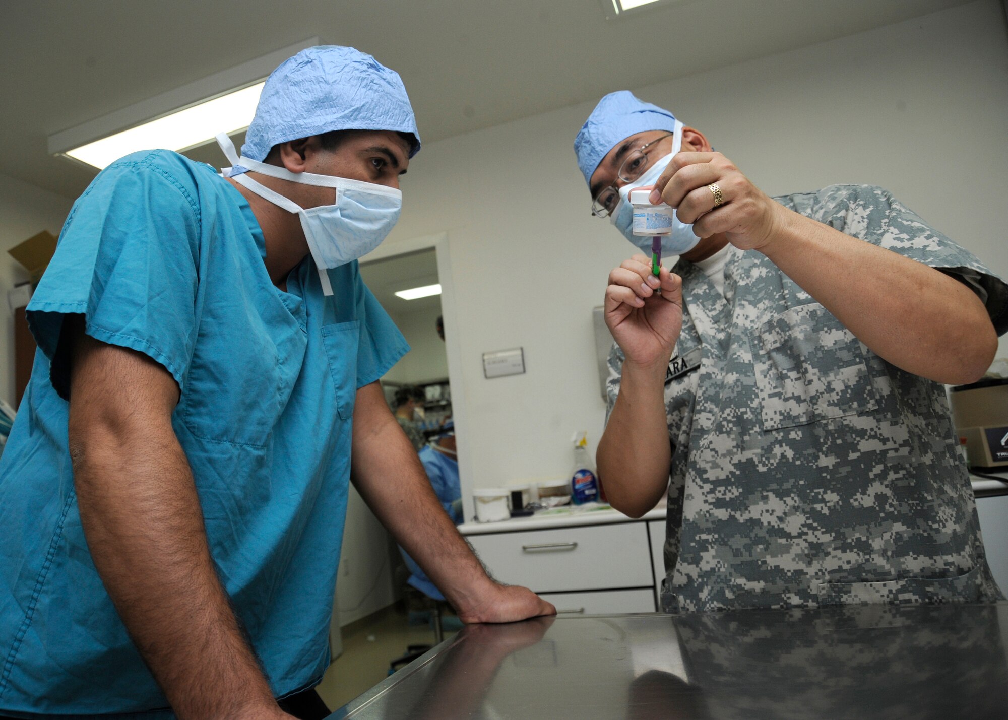 Major Matt Takara, 51st Medical Detachment, chief medical consultant for all Iraqi theater Military Working Dog Units, examines a tumor extracted from a patient with a Baghdad Police College Canine Directorate veterinarian after the procedure at Joint Base Balad, Iraq, June 28, 2010. The U.S. Army veterinarians at Balad trained two host-nation veterinarians on the ins-and-outs of small animal medicine from June 28 to July 2. (U.S. Air Force photo/ Senior Airman Matt Coleman-Foster)