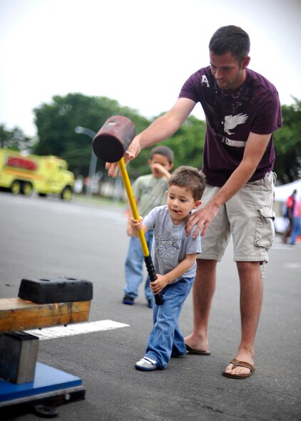 MISAWA AIR BASE, Japan -- Brayden May, son of Staff Sgt. Russ May, 301st Intelligence Squadron mission analyst, swings a hammer in an effort to ring the bell at the top during Freedom Fest July 4. Brayden swung three times eventually winning himself a prize. (U.S. Air Force photo/Staff Sgt. Chad C. Strohmeyer)