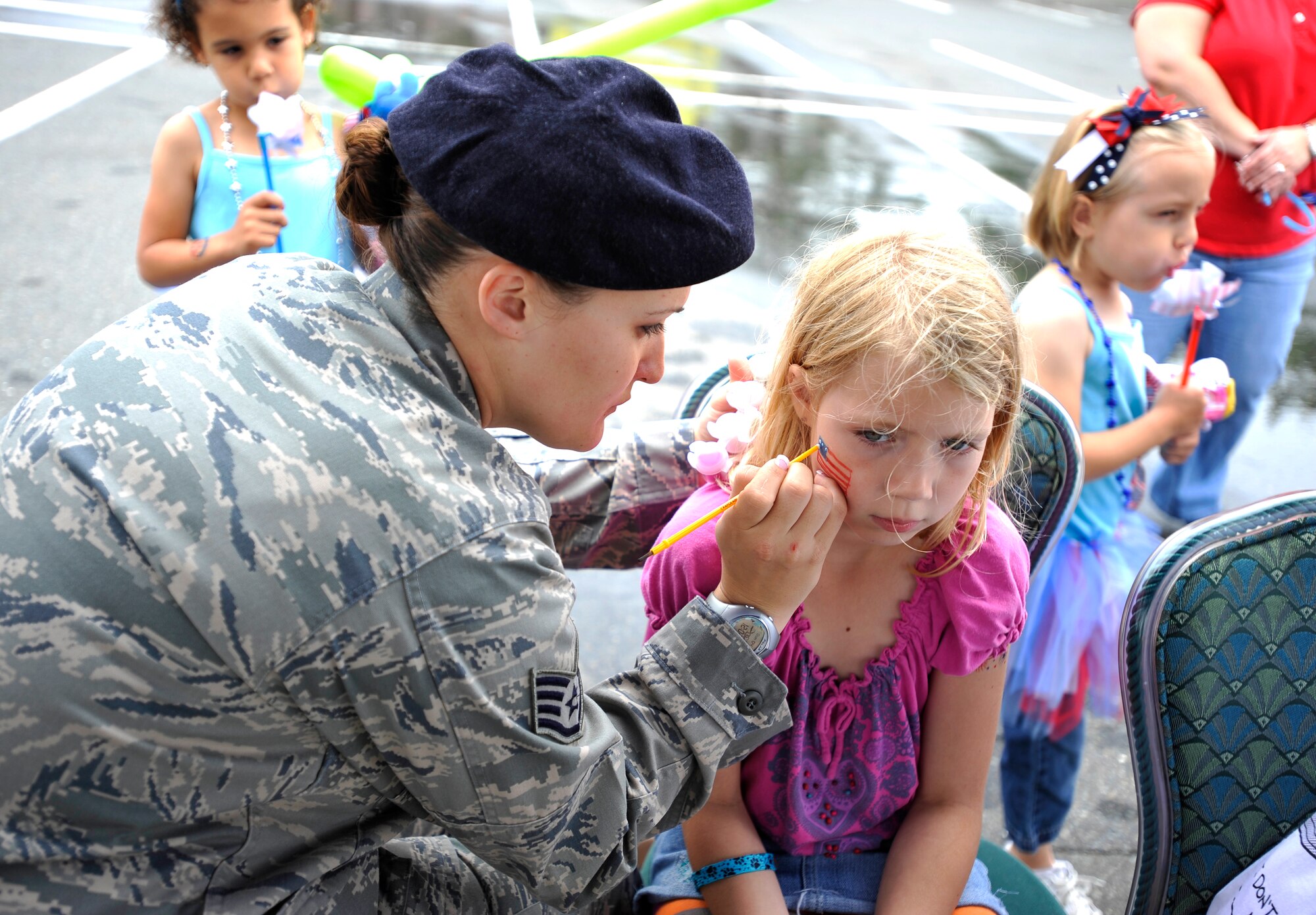 MISAWA AIR BASE, Japan -- Staff Sgt. Mindy Busshardt, 35th Security Forces Squadron patrolmen, paints an American flag on Lindsay Claire's face during Freedom Fest July 4. Lindsay is the daughter of Master Sgt. William Light, 35th Civil Engineer Squadron housing maintenance technician. (U.S. Air Force photo/Staff Sgt. Chad C. Strohmeyer)