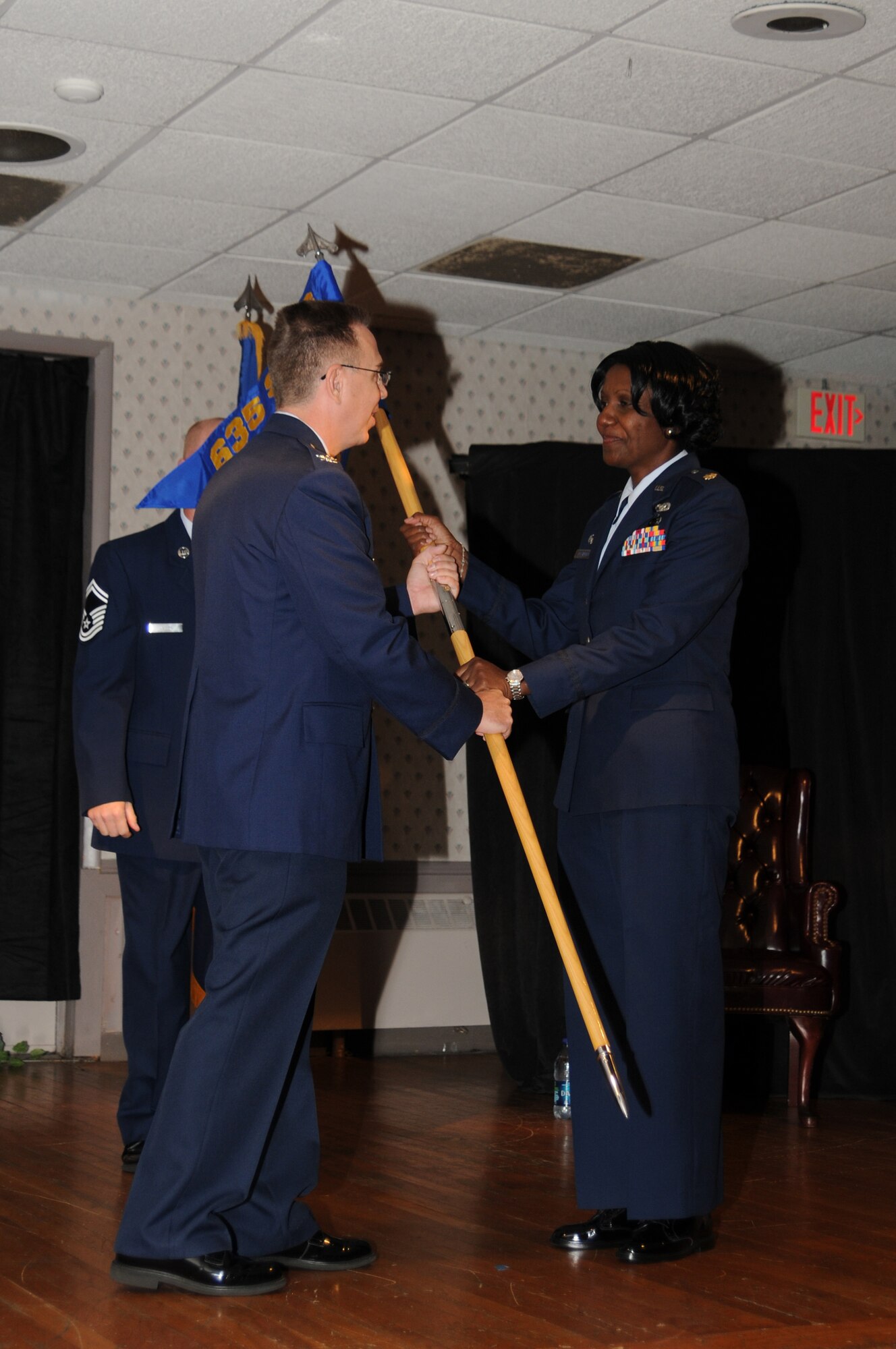 Colonel Scott J. Tew, Commander, 635th Supply Chain Operations Group, hands over the 437th Supply Chain Operations Squadron guidon to Major Majornetta Alexander, Commander of the Headquarters Illinois Air National Guard Detachment 2 and Chief of the 635th Supply Chain Management Group (SCMG) Management and Division Systems, Scott Air Force Base, Ill., during her assumption of leadership of the newly formed 437th Supply Chain Operations Squadron (SCOS), July 8 at Scott AFB. Her appointment as director of the 437th SCOS makes her the first Illinois Air National Guard officer to be appointed to such a position under the Air Force's Total Force Initiative.