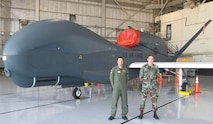 (Left) Cadets First Class Jeremy Granow and Austin Kootz pose in front of a Global Hawk during their three-week U.S. Air Force Academy Cadet Summer Research Program tour with the Air Force Operational Test and Evaluation Center’s Detachment 5 at Edwards AFB, Calif. Both cadets designed a user-friendly database for the programs Global Hawk, Predator, Battlefield Airborne Common Node, Multi-Platform-Radar Technology Insertion Program, and Advance Signals Intelligence Platform. (U.S. Air Force photo).