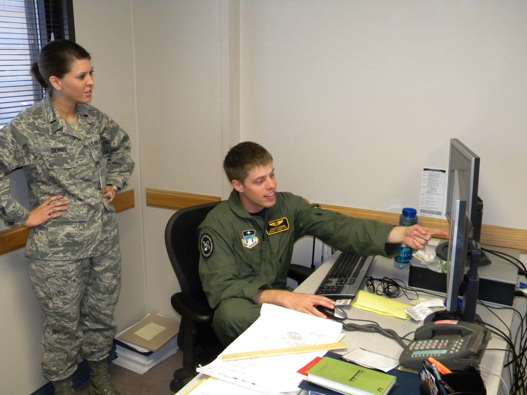 1st Lt. Cara Dennis from the Air Force Operational Test and Evaluation Center’s Detachment 6 at Nellis AFB, Nev., works with Cadet First Class Joseph Boben as he builds an assessment of Circular Error Point calculation methods for bomb drop data. During the U.S. Air Force Academy Cadet Summer Research Program cadets gain hands-on exposure to operational testing processes, products, and experiences. (U.S. Air Force photo).