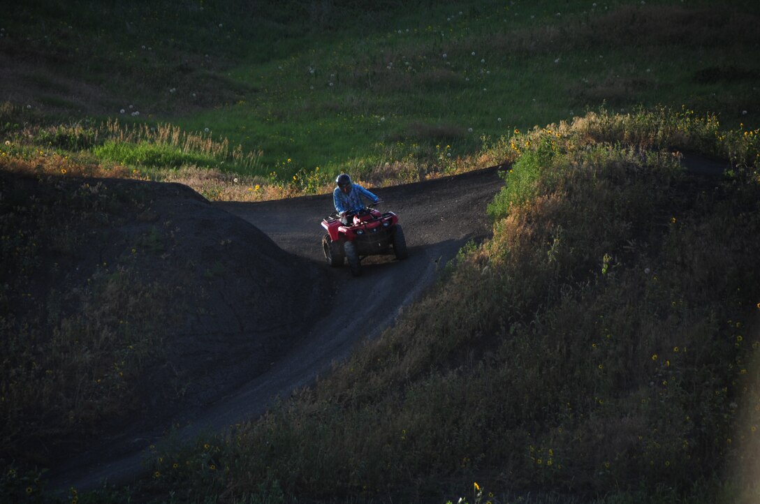 ELLSWORTH AIR FORCE BASE, S.D. -- Airman 1st Class Michael Obringer, 28th Maintenance Squadron aircrew egress systems journeyman, rides an all-terrain vehicle down a hill at the Buffalo Gap National Grasslands, S.D., July 7.  Airman Obringer goes slowly down the hill making sure not to flip the ATV. (U.S. Air Force photo/Airman 1st Class Anthony Sanchelli)