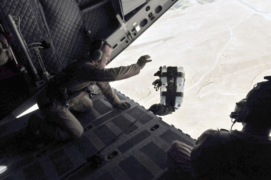 Master Sgt. Chris Ringland thrusts the cargo out as Staff Sgt. Talon Martin watches during an airdrop July 1, 2010, over Afghanistan. Sergeant Ringland is with the 438th Air Expeditionary Advisory Group and Sergeant Martin is with the 538th Air Expeditionary Advisory Squadron. (U.S. Navy photo/Petty Officer 2nd Class David Quillen)